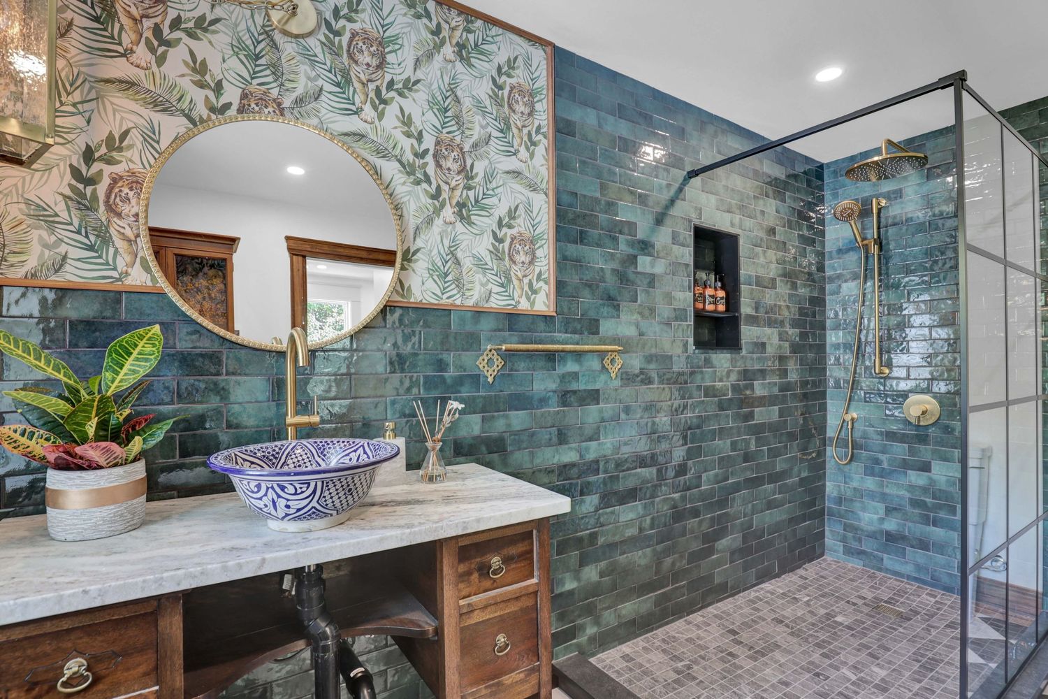 Elegant bathroom design with teal tiled walls and wooden vanity cabinet.