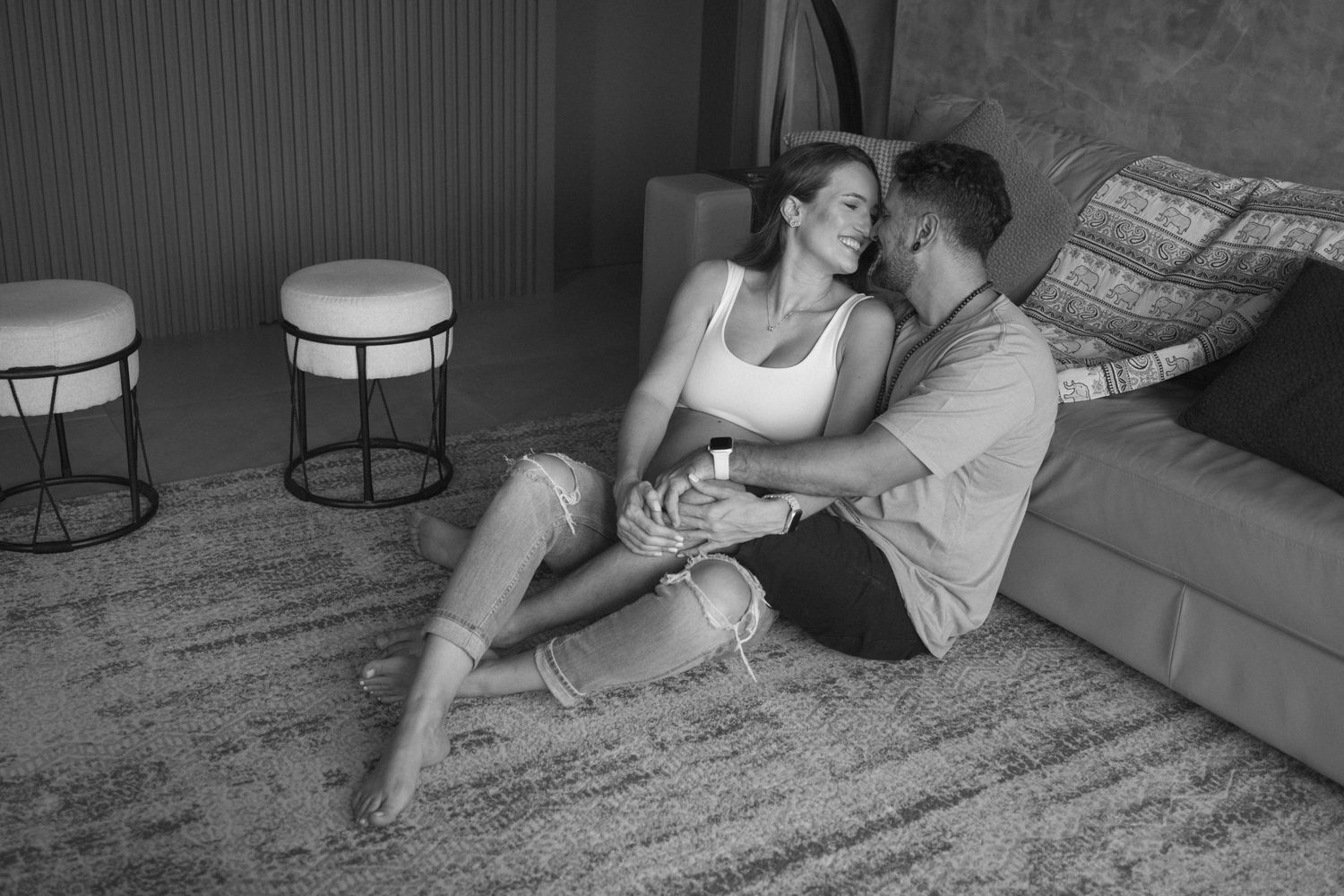 Couple relaxing together on carpet during an indoor photo session.