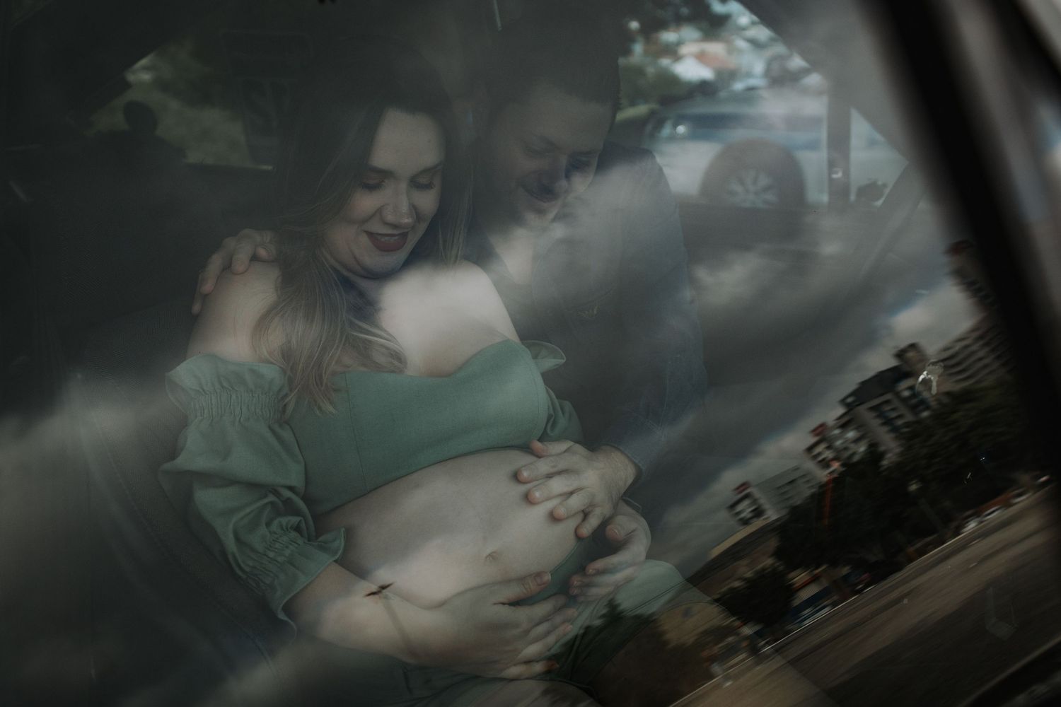 A couple embraces in a series of intimate moments photographed through a car window.