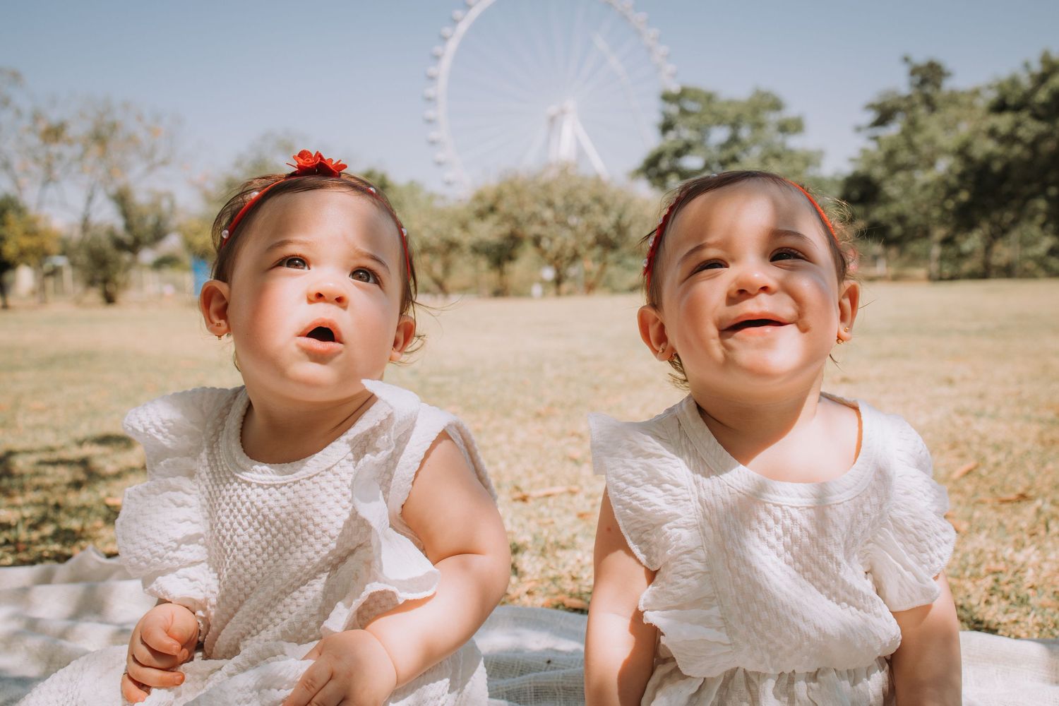 Two children sharing joyful expressions during an outdoor photo session.