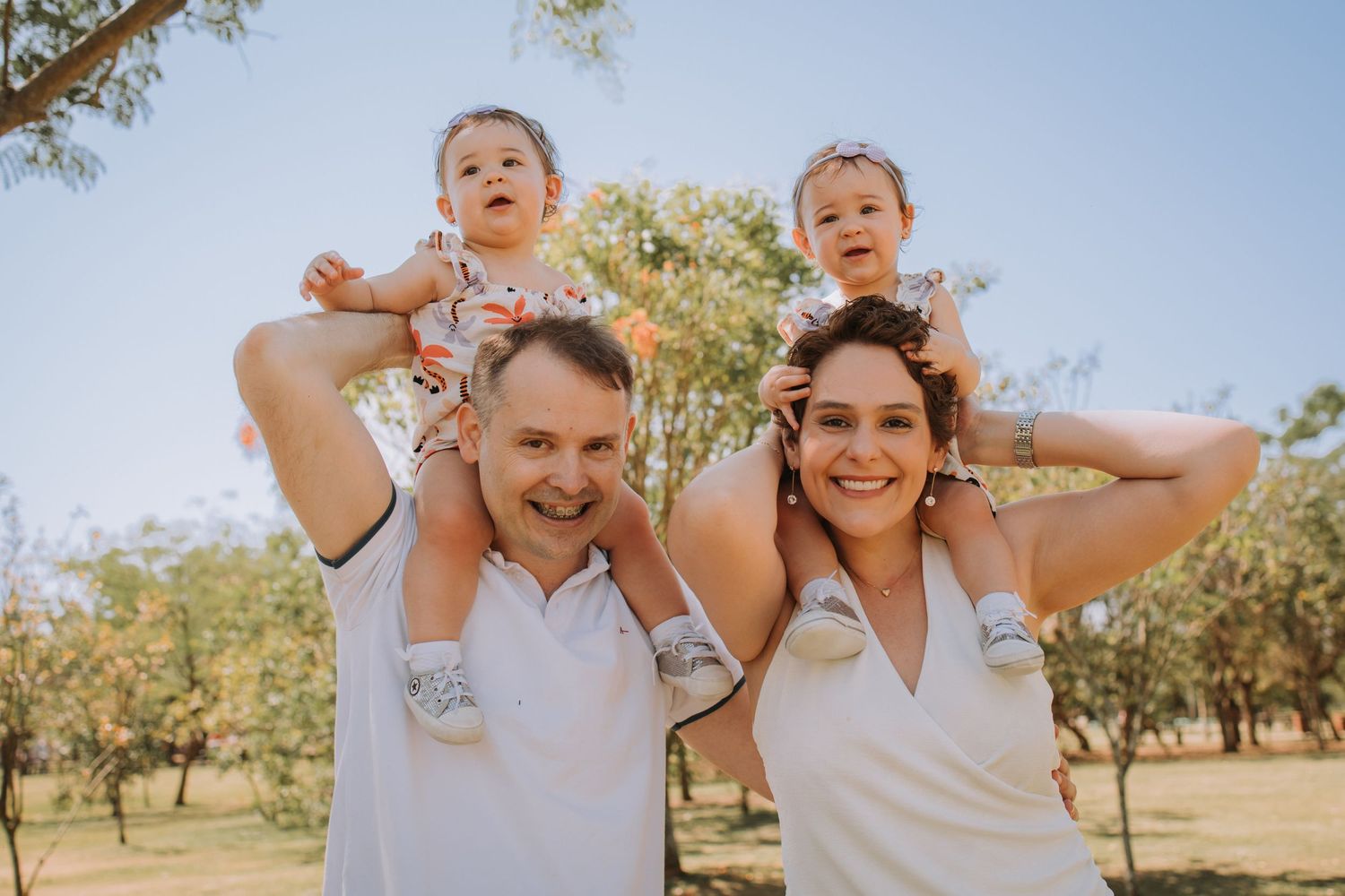 Candid family moments captured against a bright blue sky in an outdoor setting.
