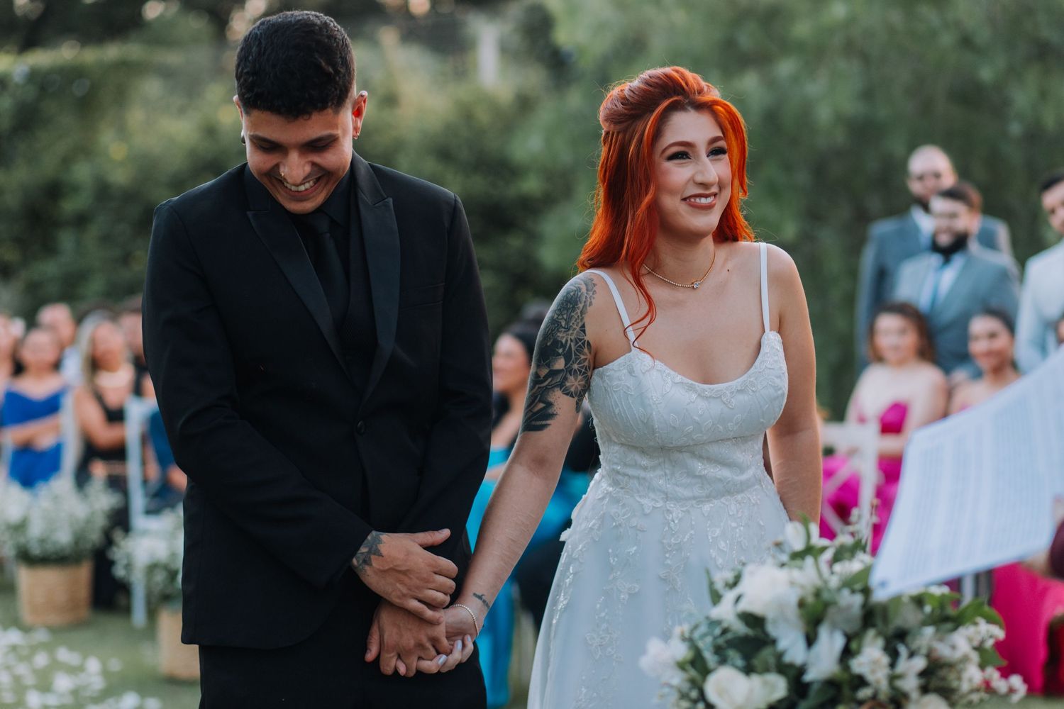 A couple shares an intimate moment during their outdoor wedding ceremony in a garden setting.