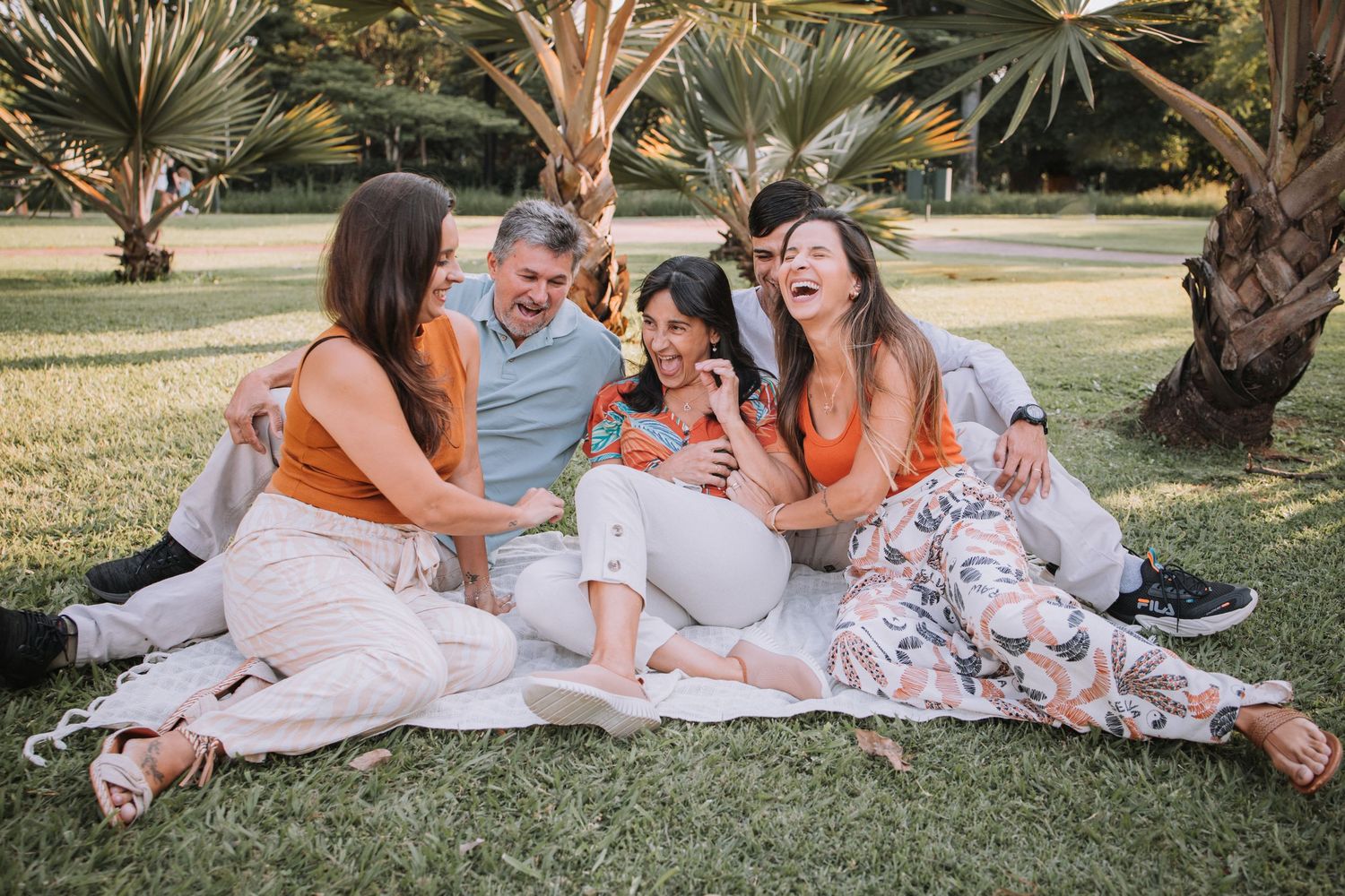Family members enjoying candid moments together during outdoor photo shoot.