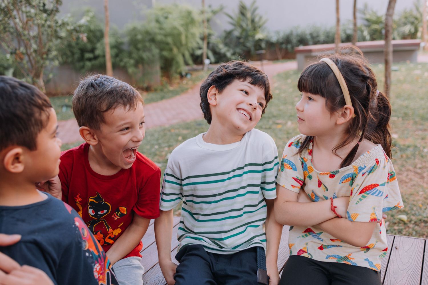 Candid outdoor photography of children laughing and playing together in natural setting.