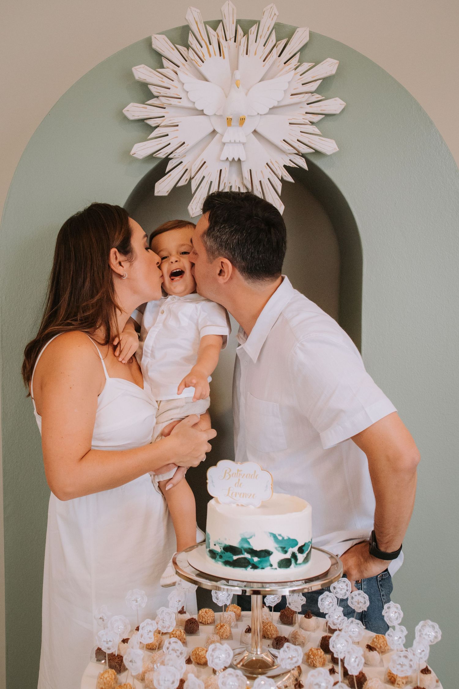 A family celebrates around a white cake display under an elegant starburst decoration.