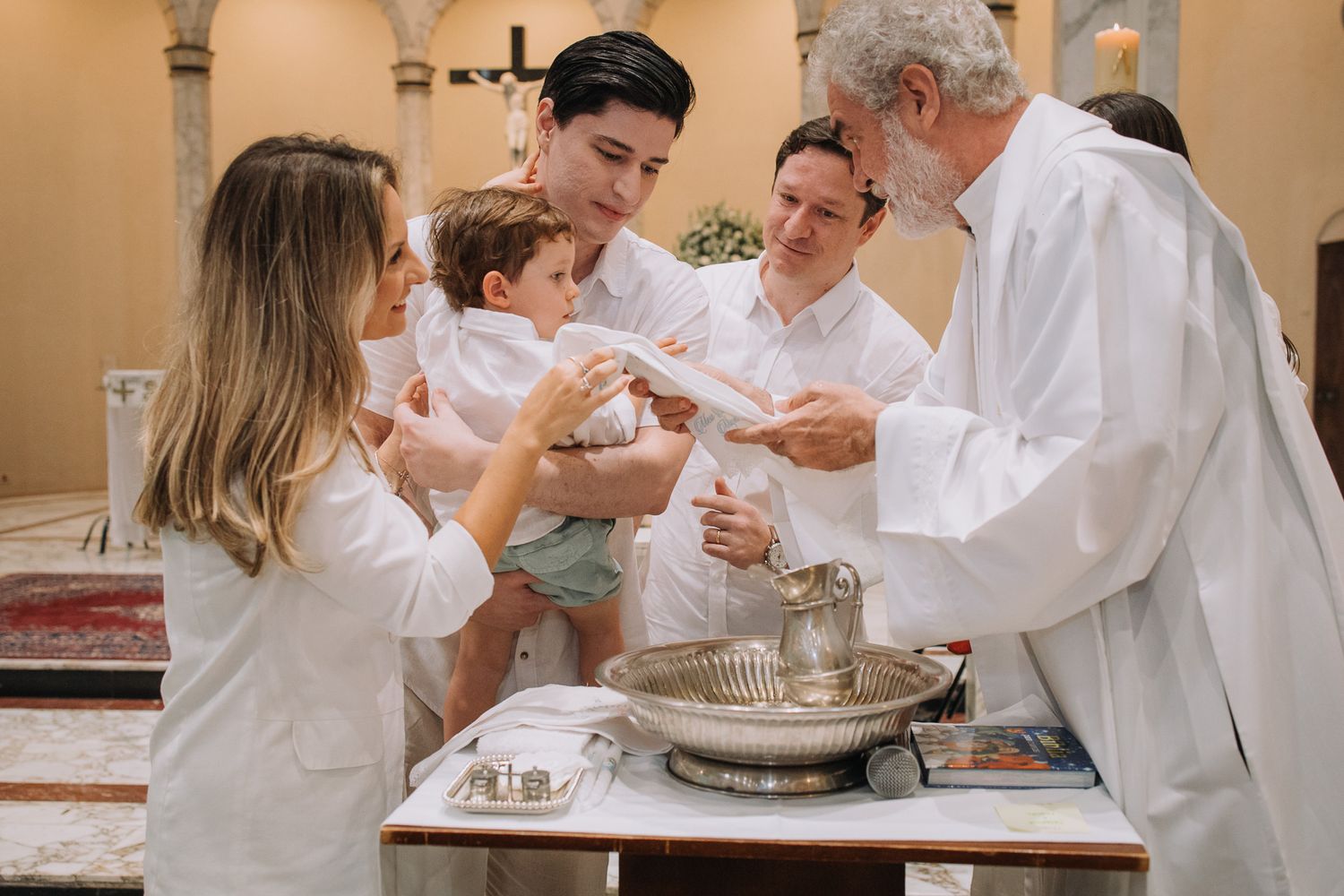 A religious ceremony takes place with family members gathered around a church altar.