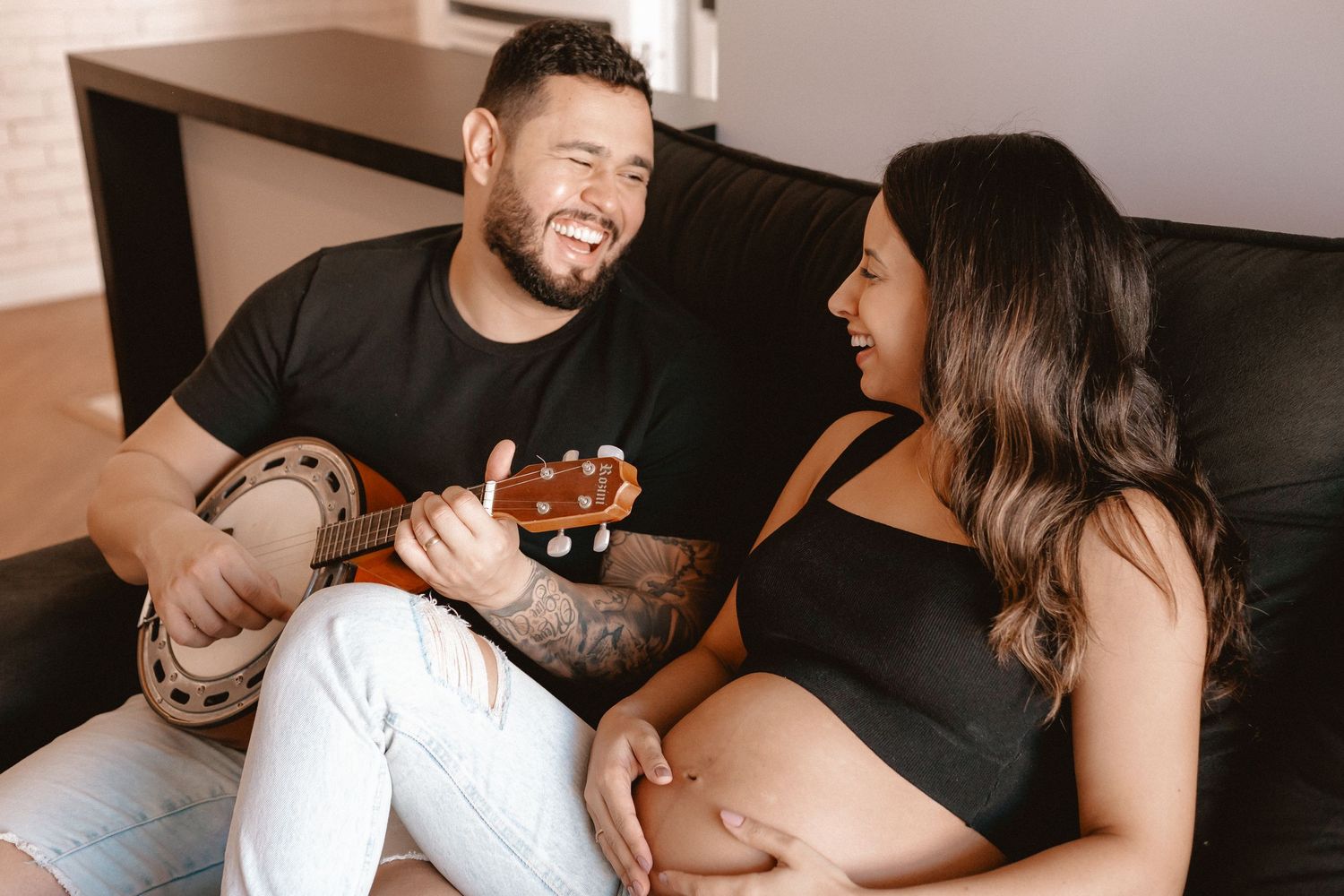 Candid maternity photos capturing joyful laughter and intimate moments.