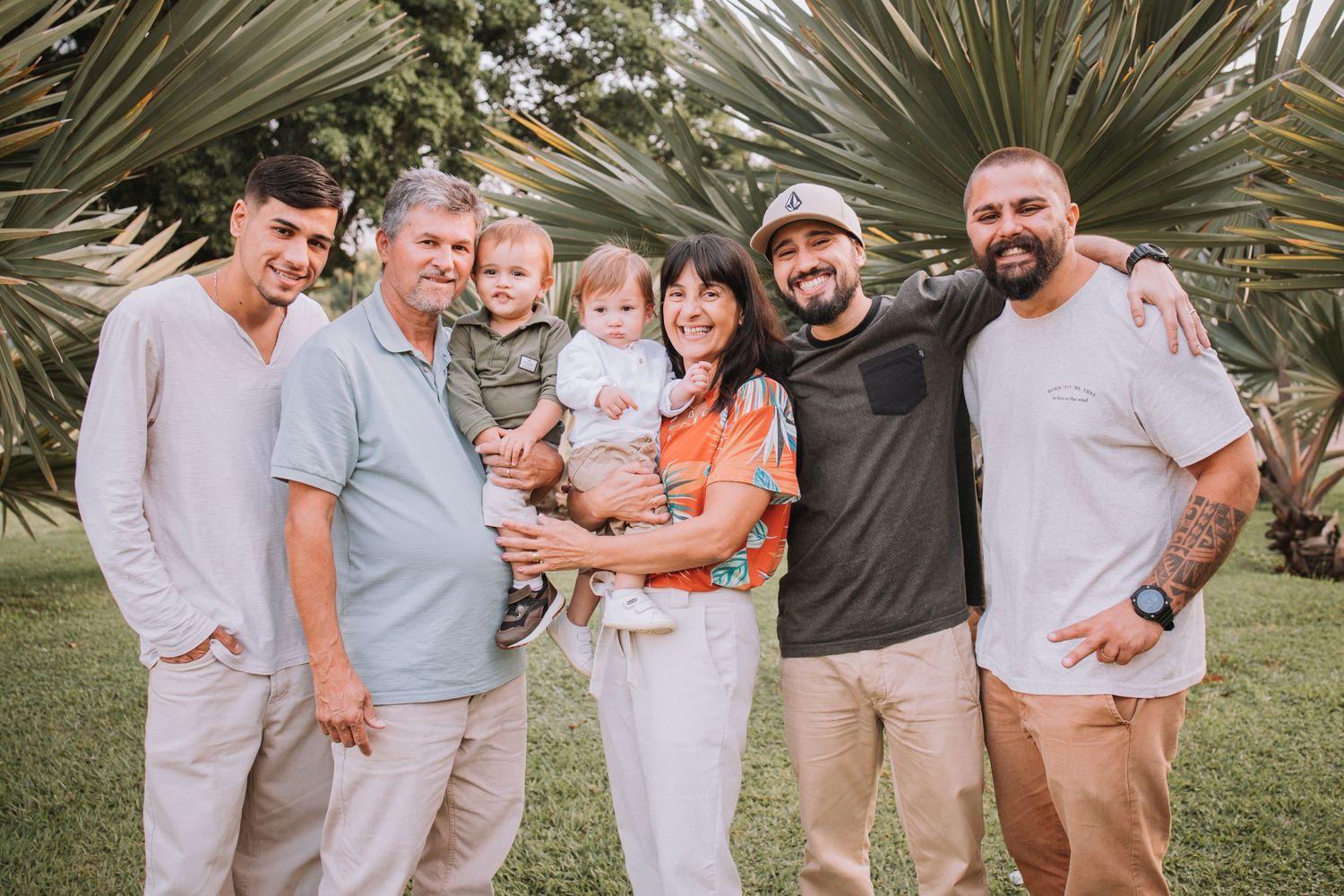 Extended family gathering for casual outdoor photo session in natural setting.