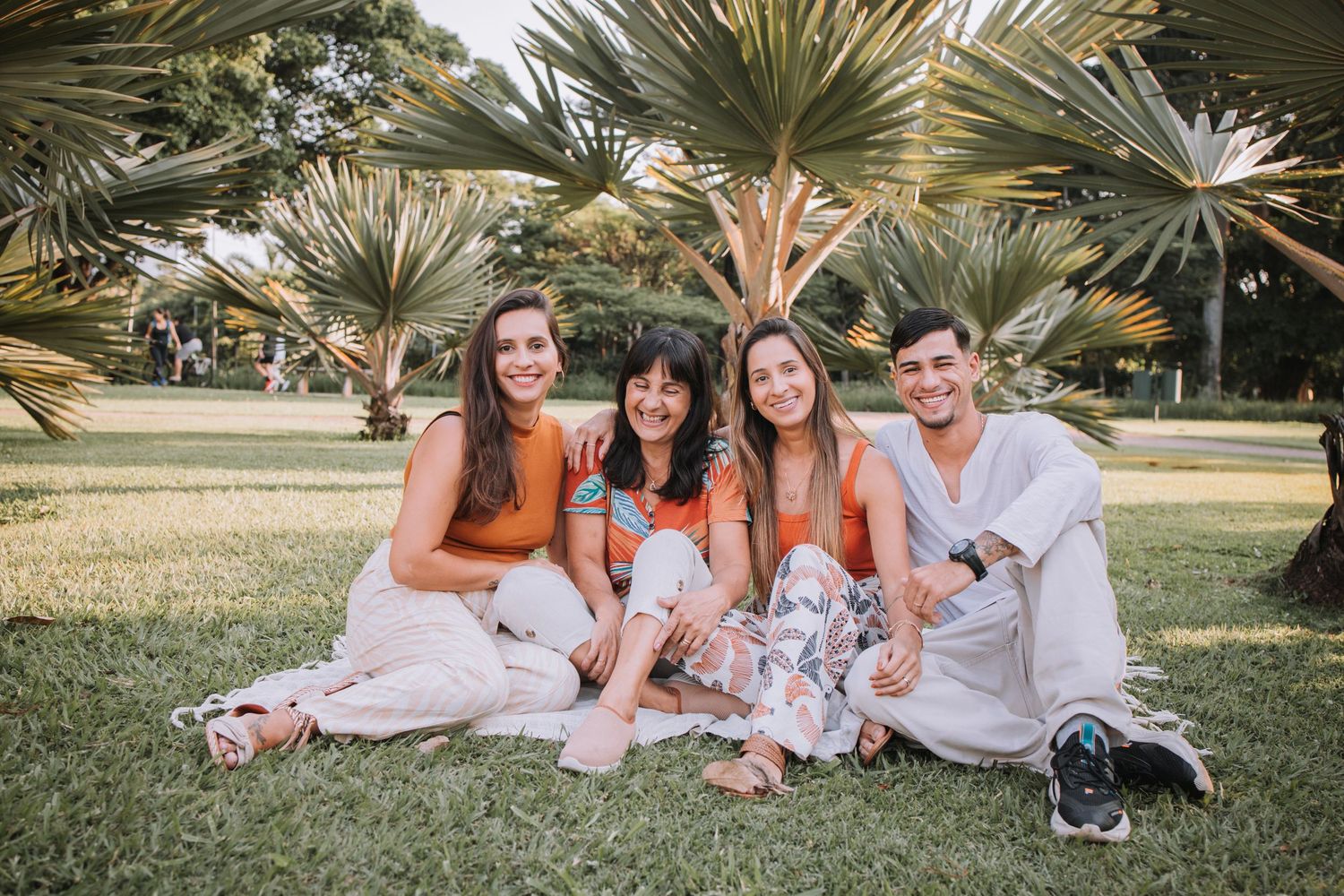 Family members in orange and white outfits having fun during outdoor photo shoot.