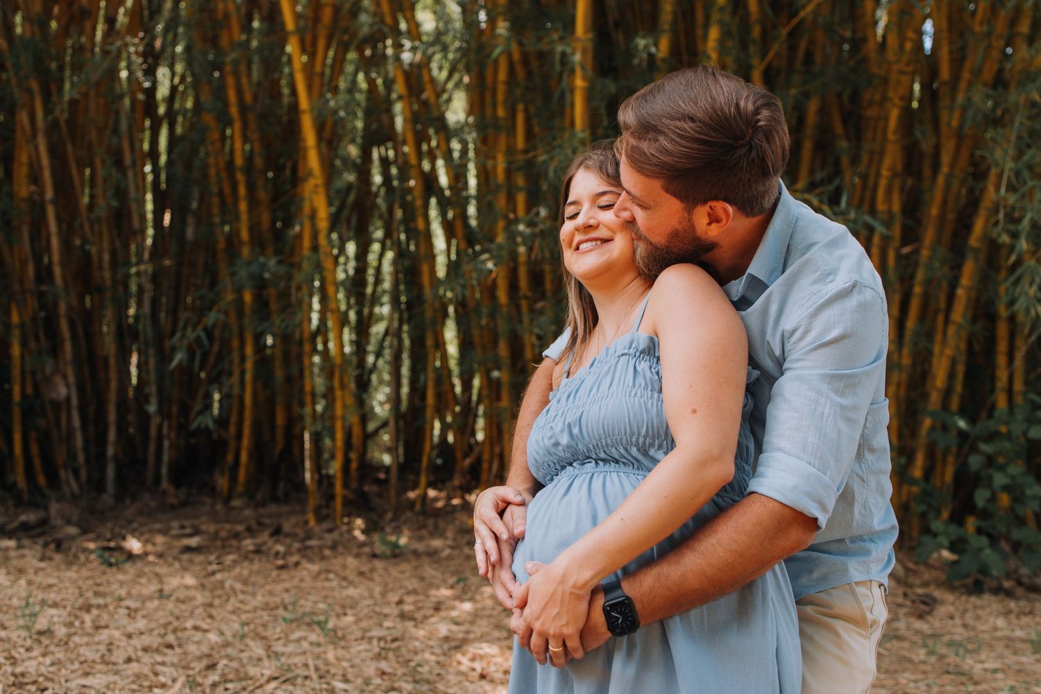 Couple sharing intimate moments in a bamboo forest setting.