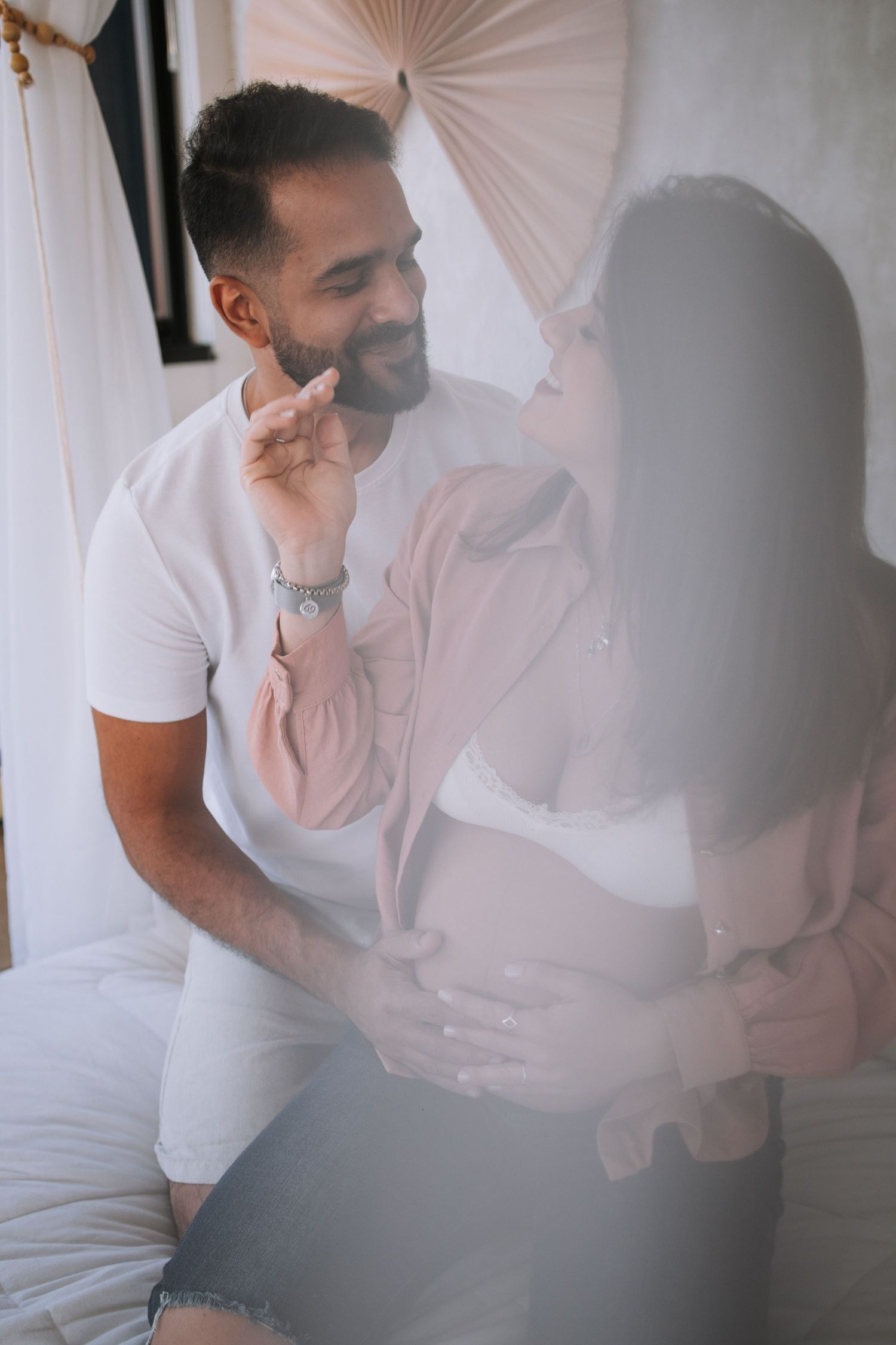 An intimate photoshoot with white draping fabric in the background.