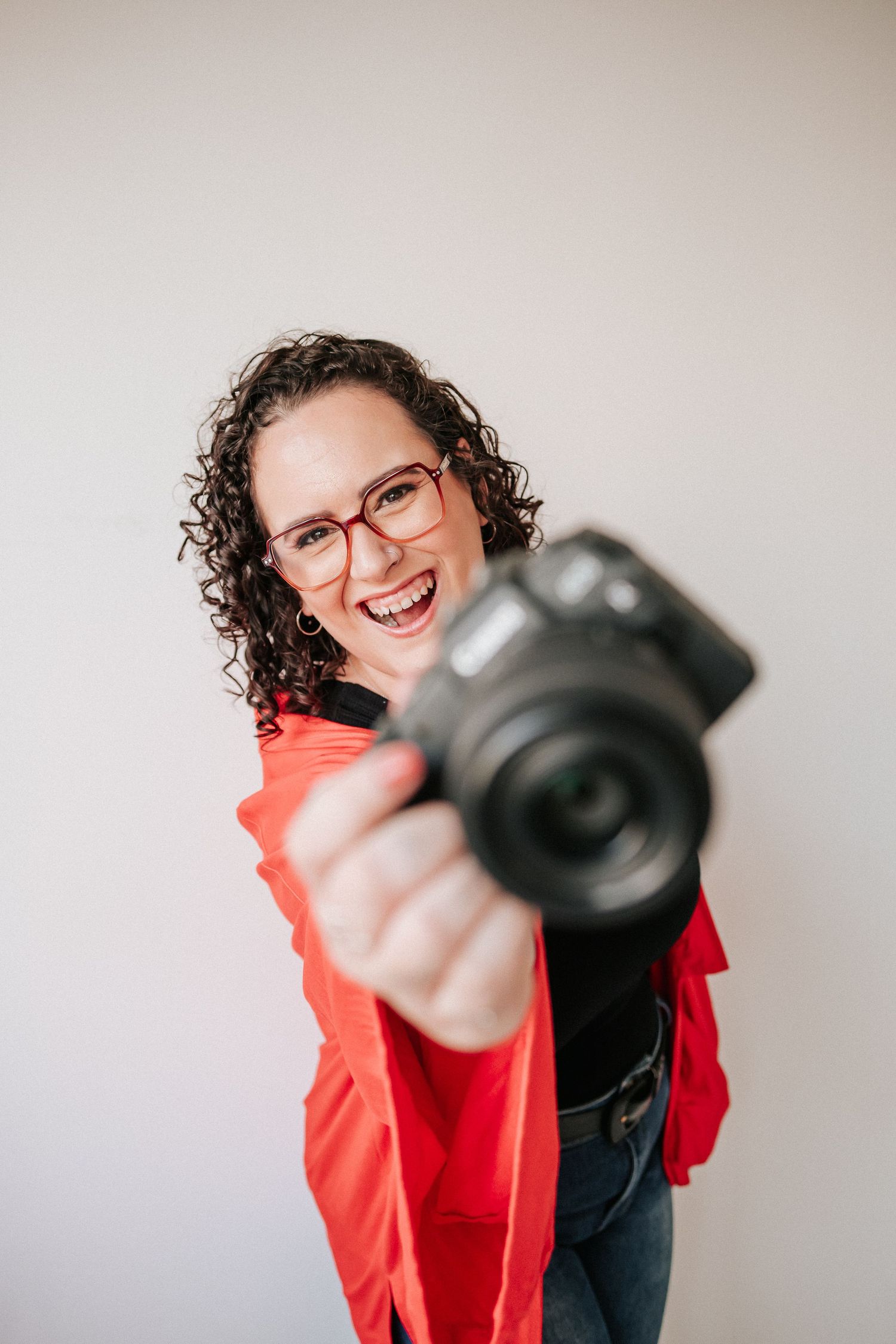 Person in red shirt and glasses playfully points camera at viewer in progressive sequence of fun poses.