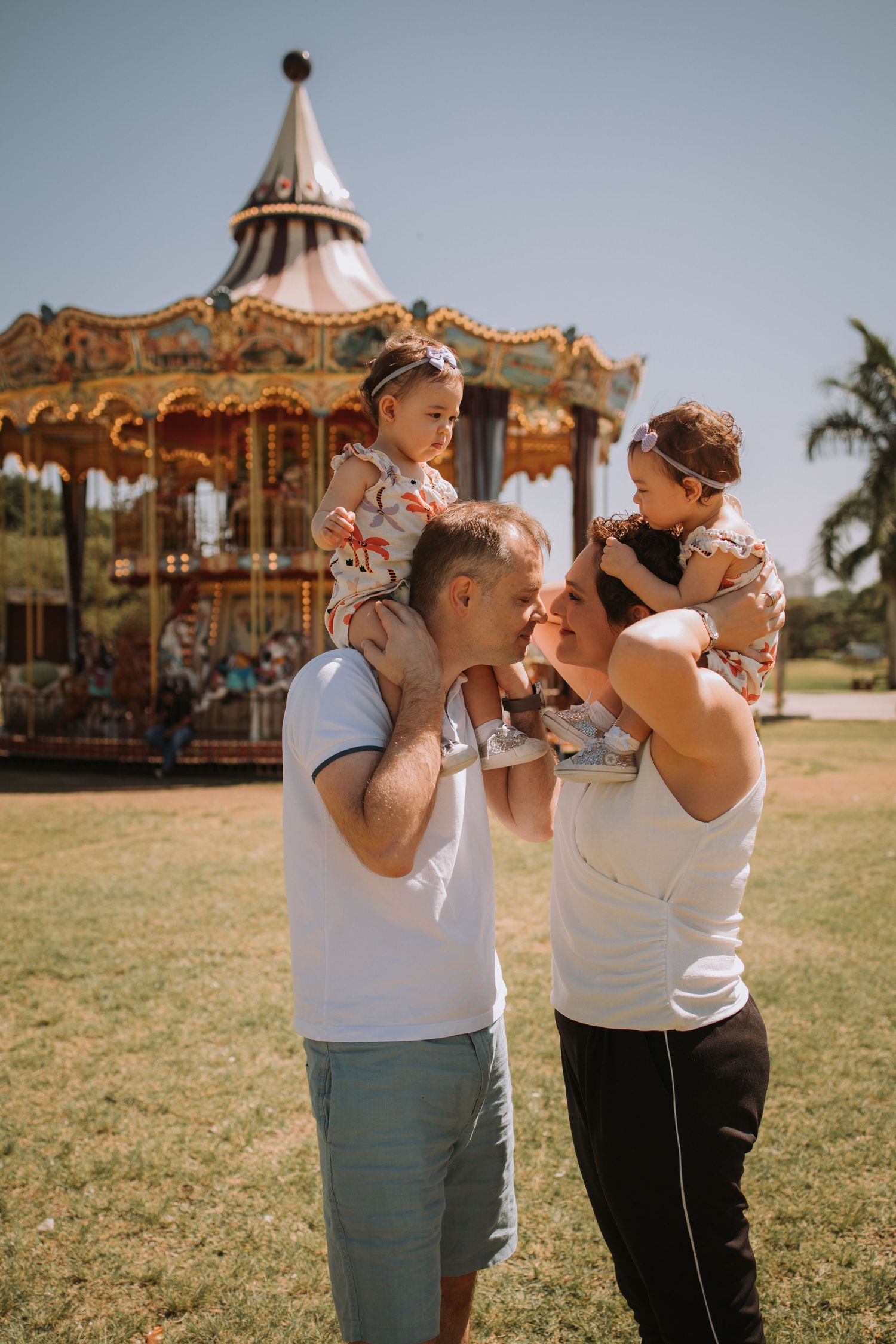 Family photoshoot series with a vintage carousel in the background.