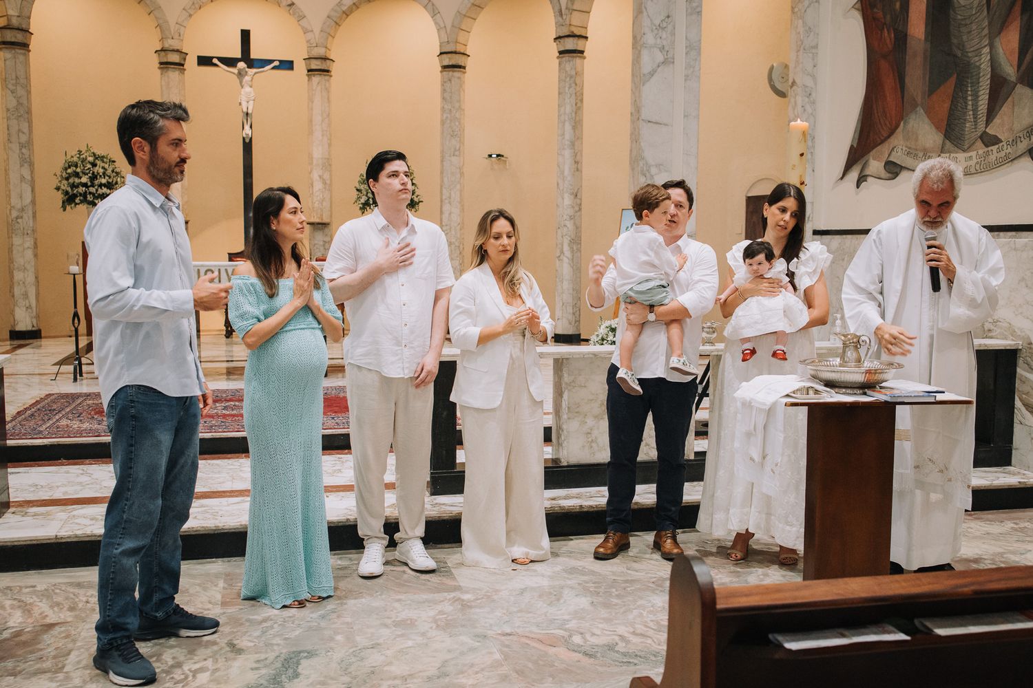 A group of people in white attire participate in a church ceremony.