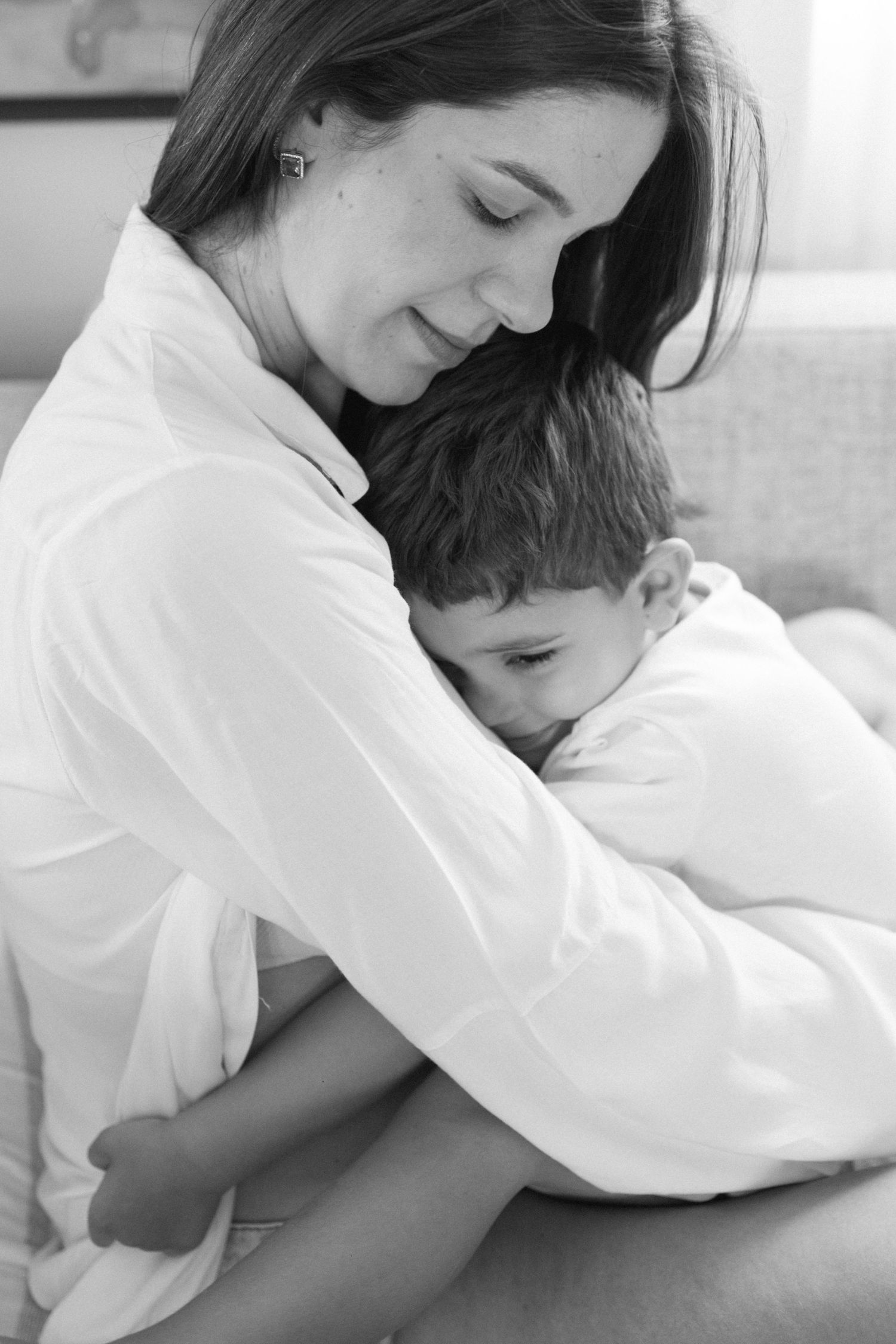 Black and white photo of tender family moments on a couch.