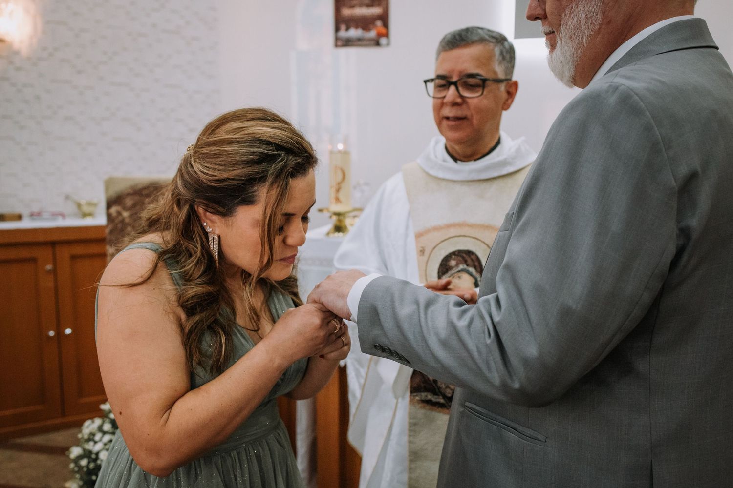 A tender moment between a couple during their wedding ceremony in a church setting.