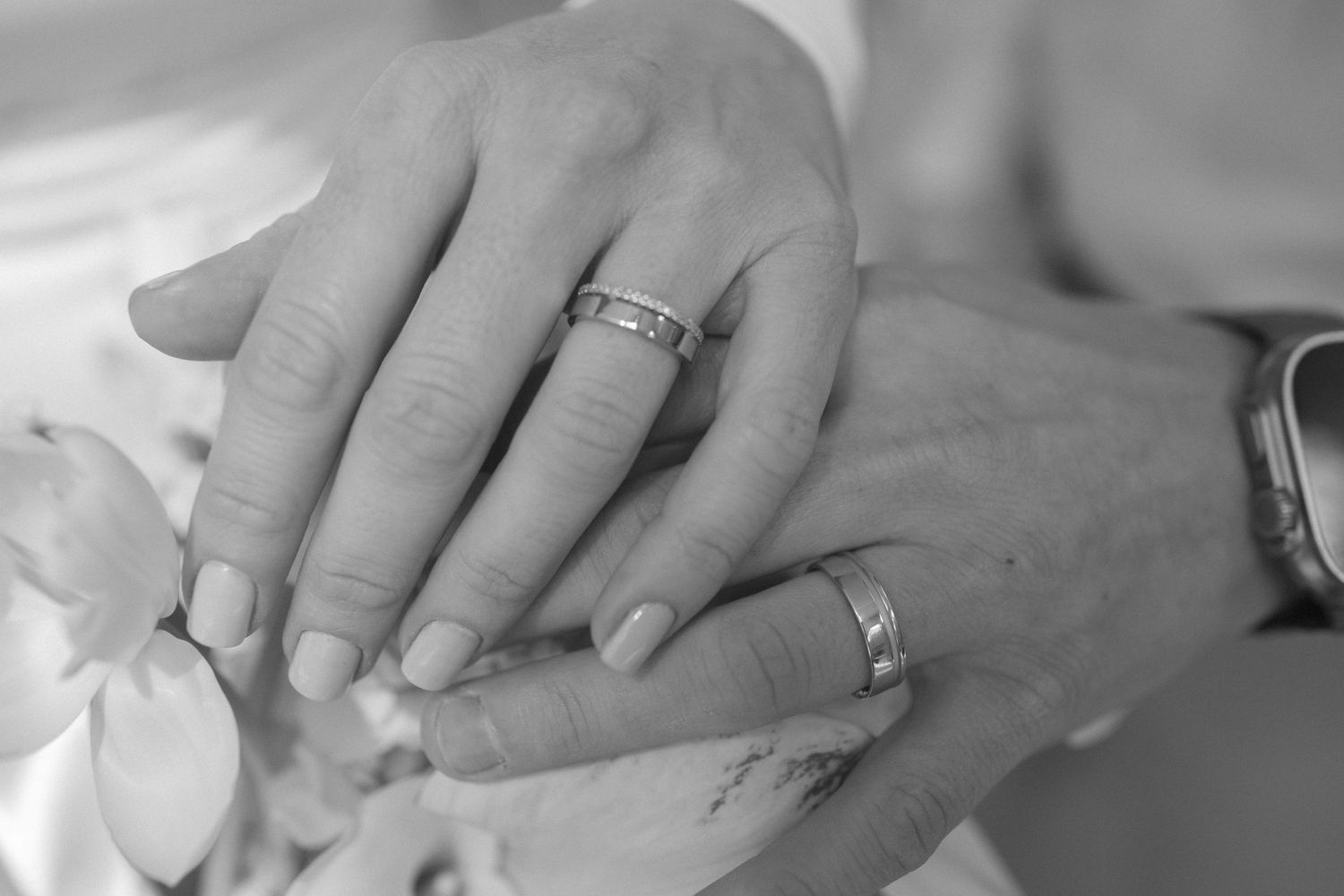 Black and white close-up photo showing hands holding a small baby's feet with tender care.