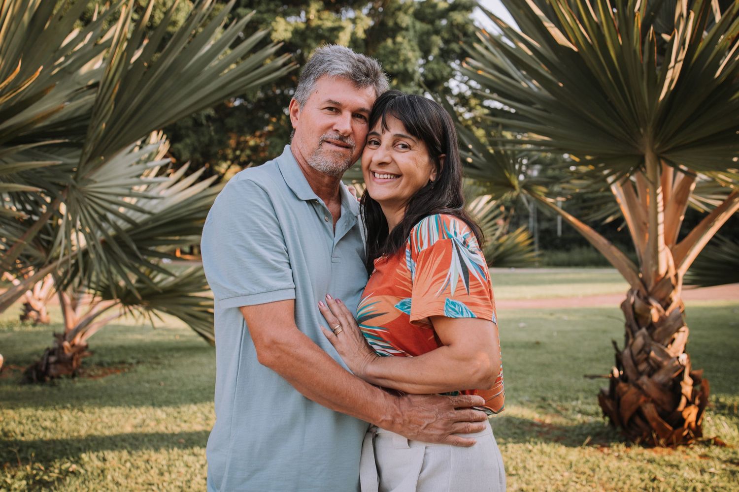 Candid family moment captured under palm trees in natural outdoor setting.