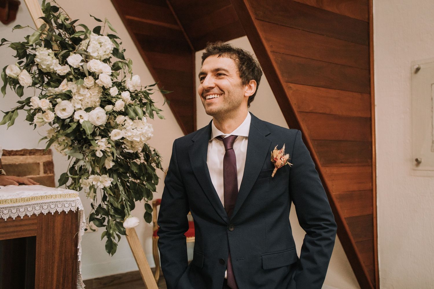Wedding party members in black suits laugh and share a joyful moment during a celebration.