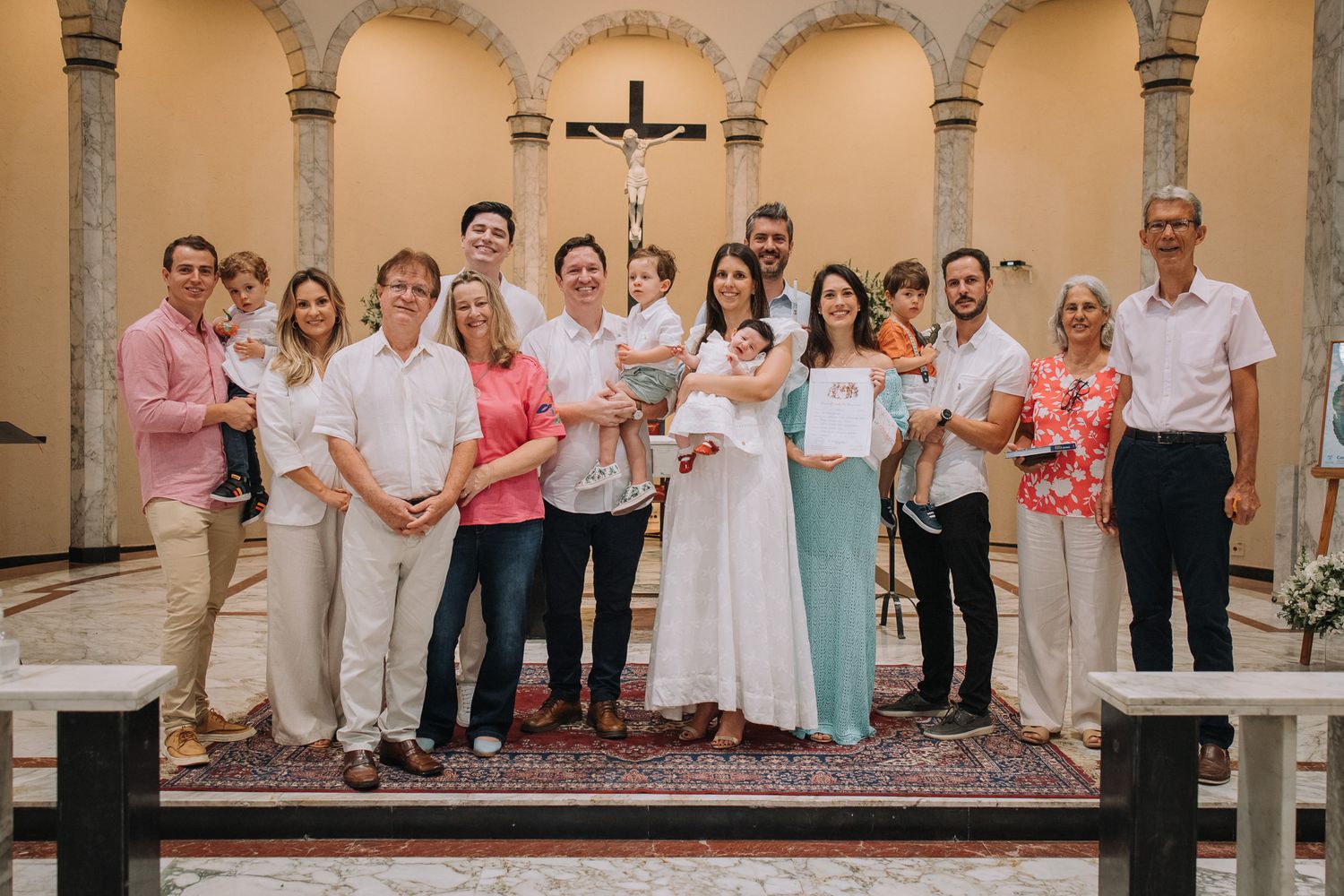 Large family gathering posed under arched colonnade for formal group photo.