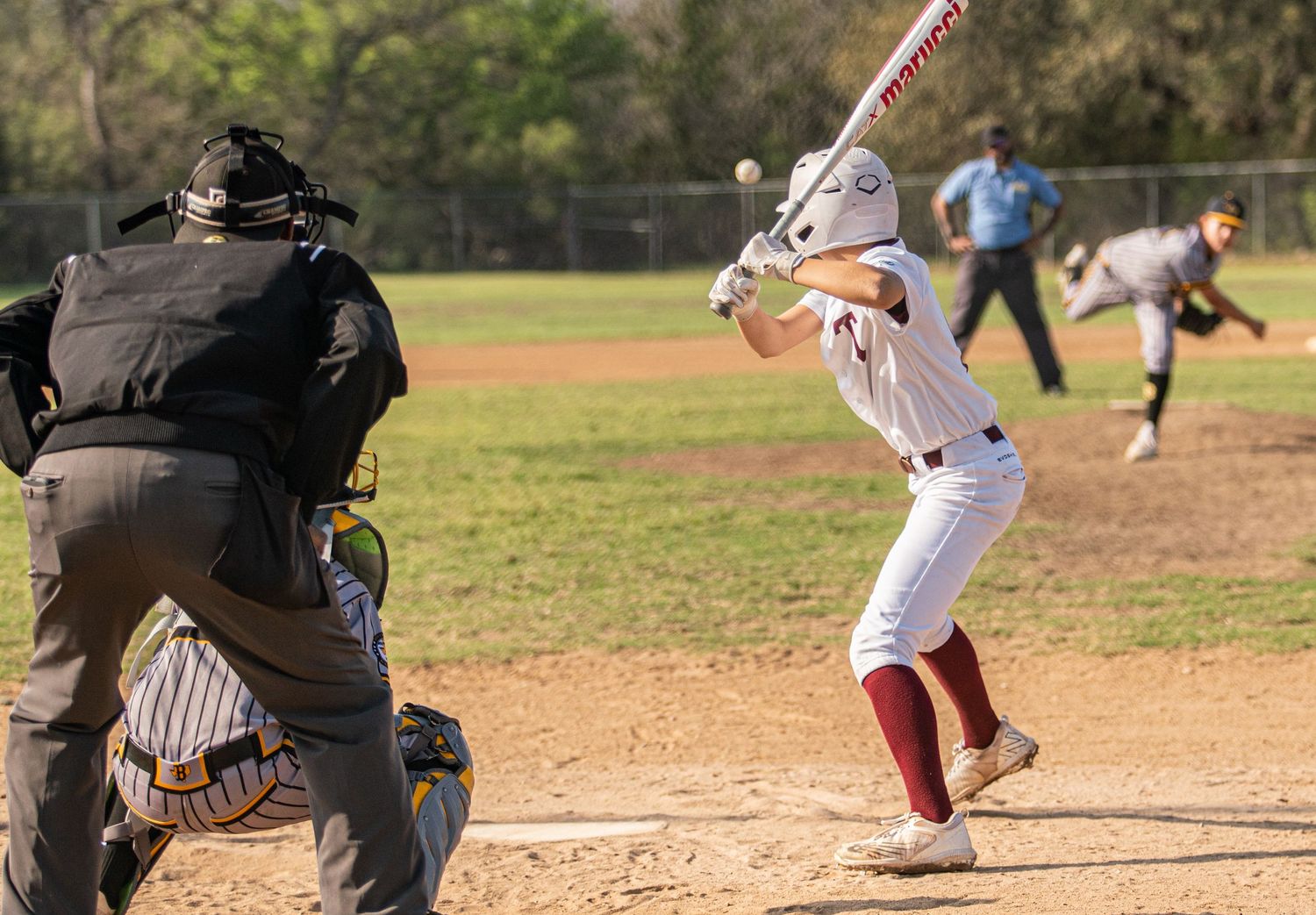 Baseball players in action showing batting sequence and catcher on sunny field.