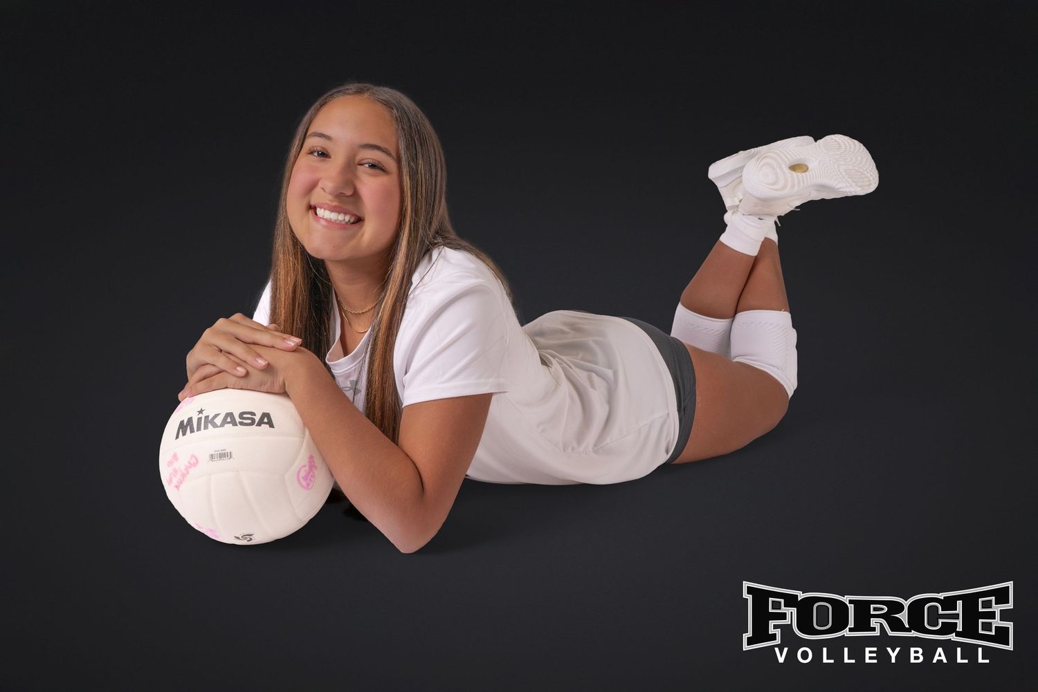 Studio portraits of Force Volleyball player with Mikasa ball against black background.