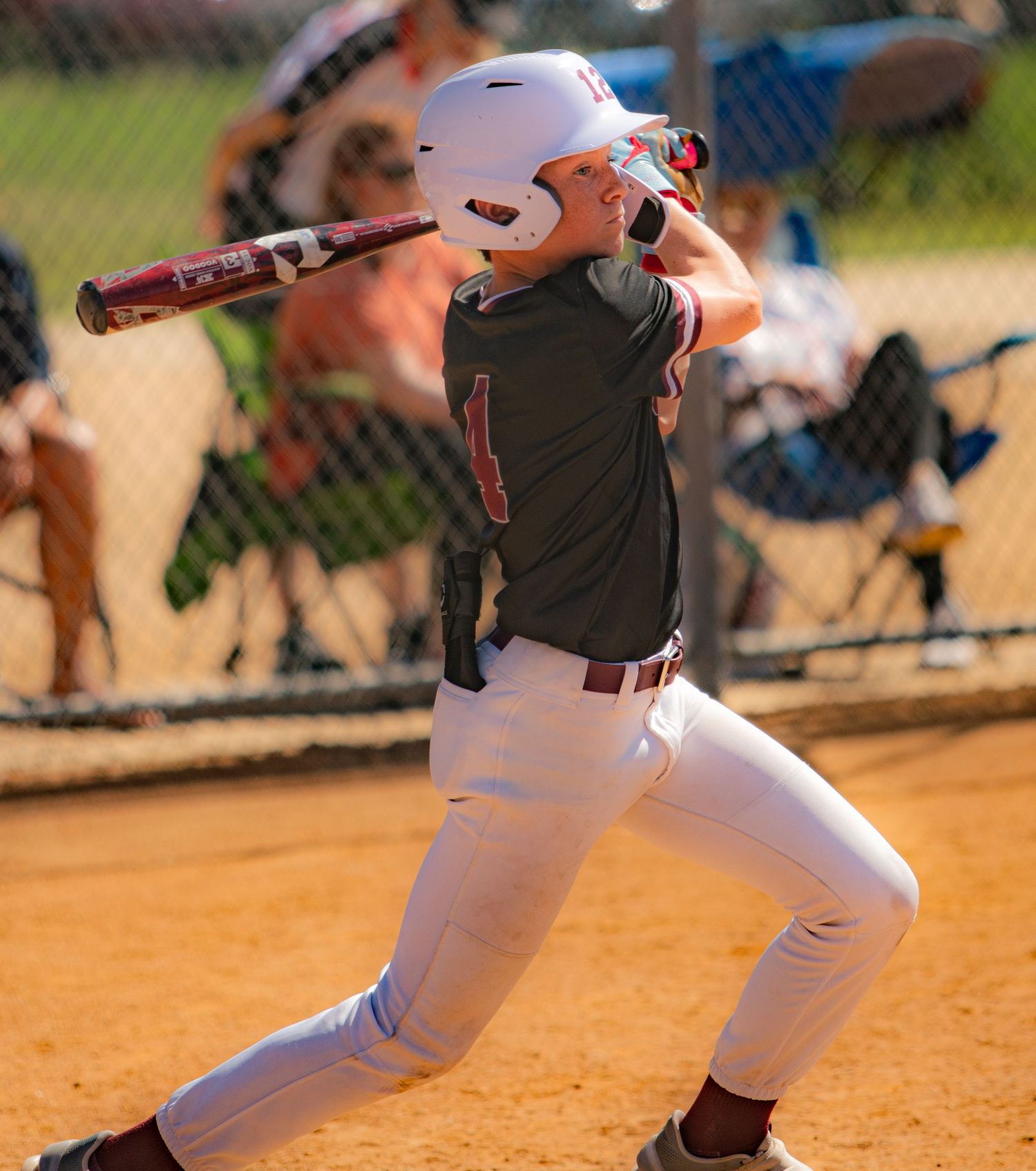 Baseball players running and sliding on dirt base paths during gameplay.