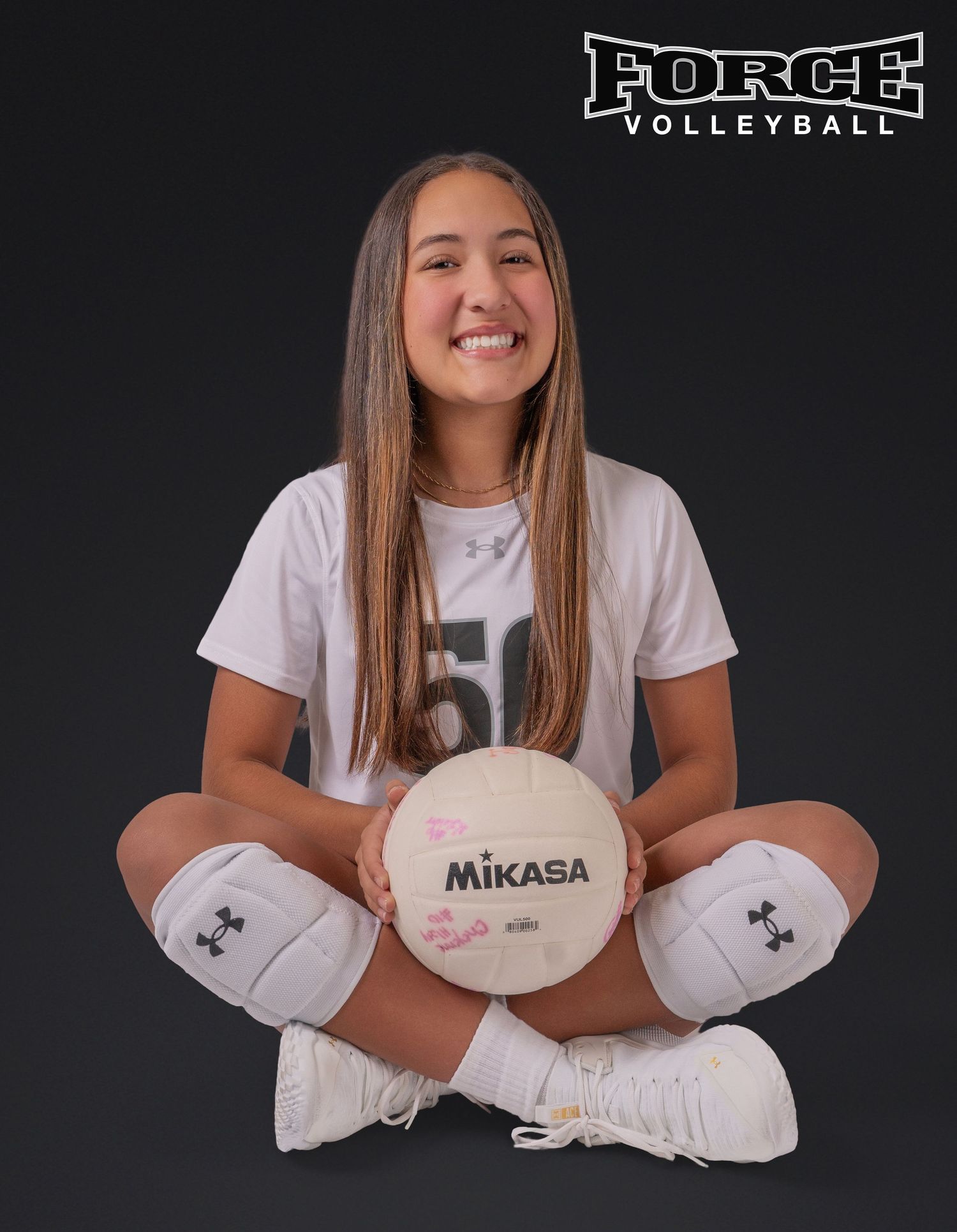 Force Volleyball player in white jersey poses with Mikasa volleyball in studio setting.