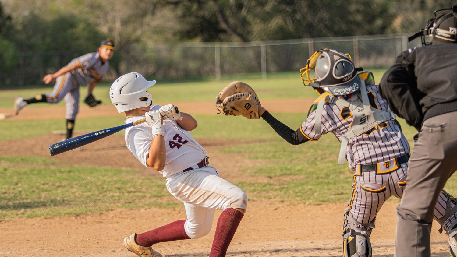 Baseball action sequence showing players batting and fielding on sunny grass field.