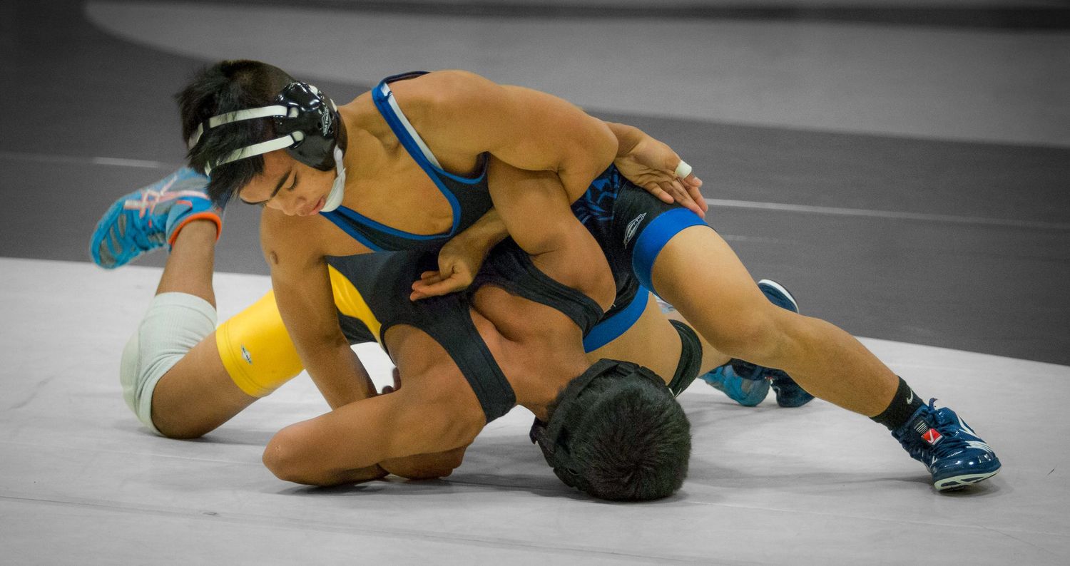 Athletes demonstrate wrestling techniques during a competitive match.