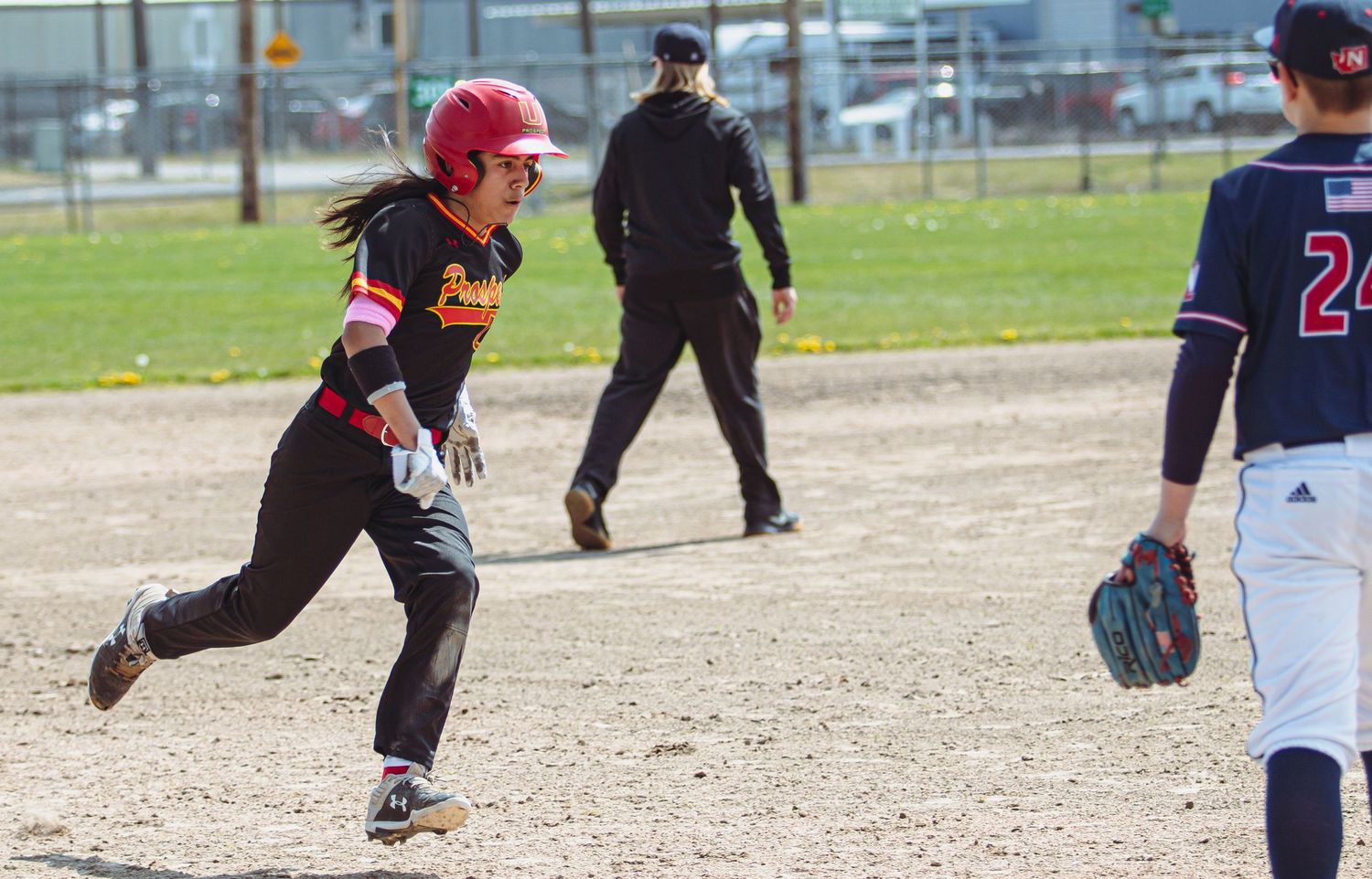 Baseball players run between bases during an active play.