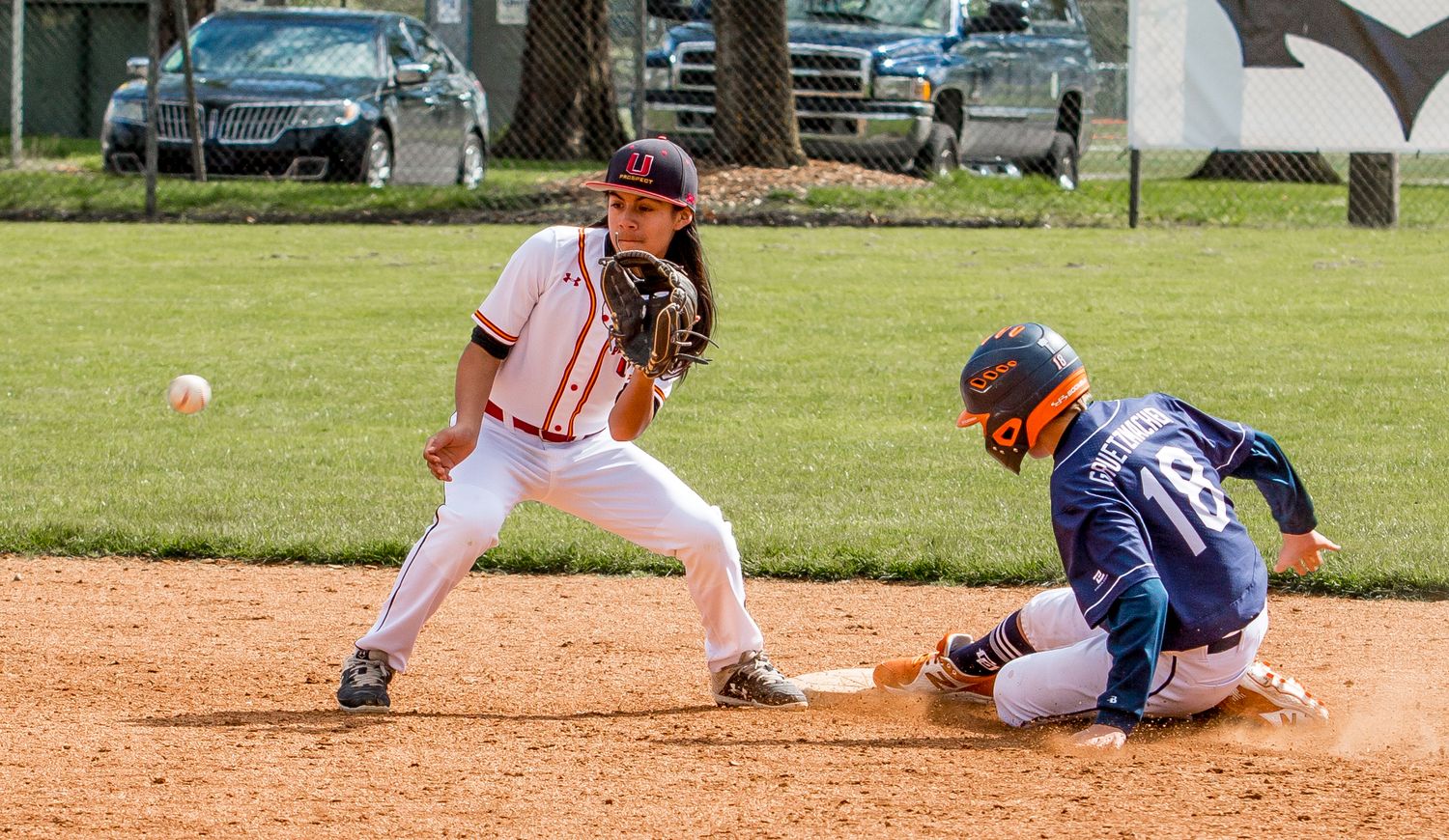 Baseball players sliding into bases during competitive game action.