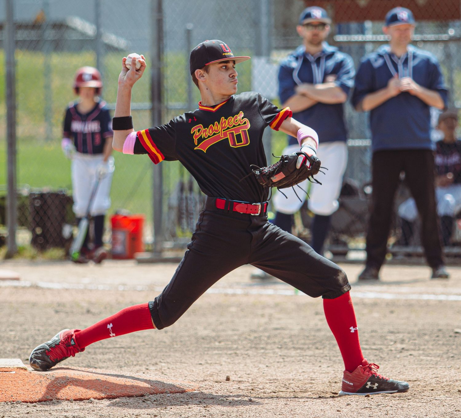 Baseball player slides into base with dramatic form during competitive game.