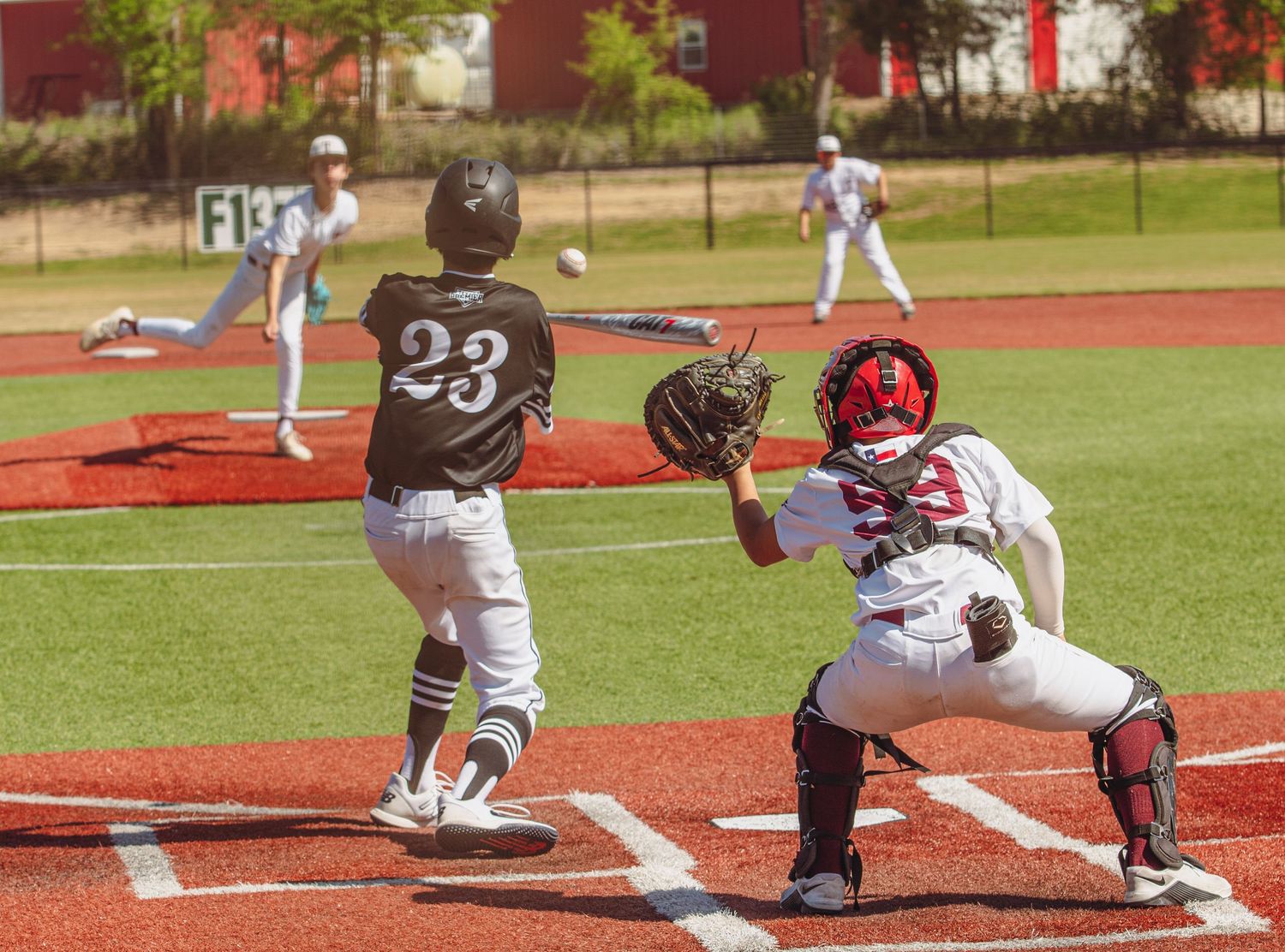 Baseball action at home plate with batter and catcher during competitive game.