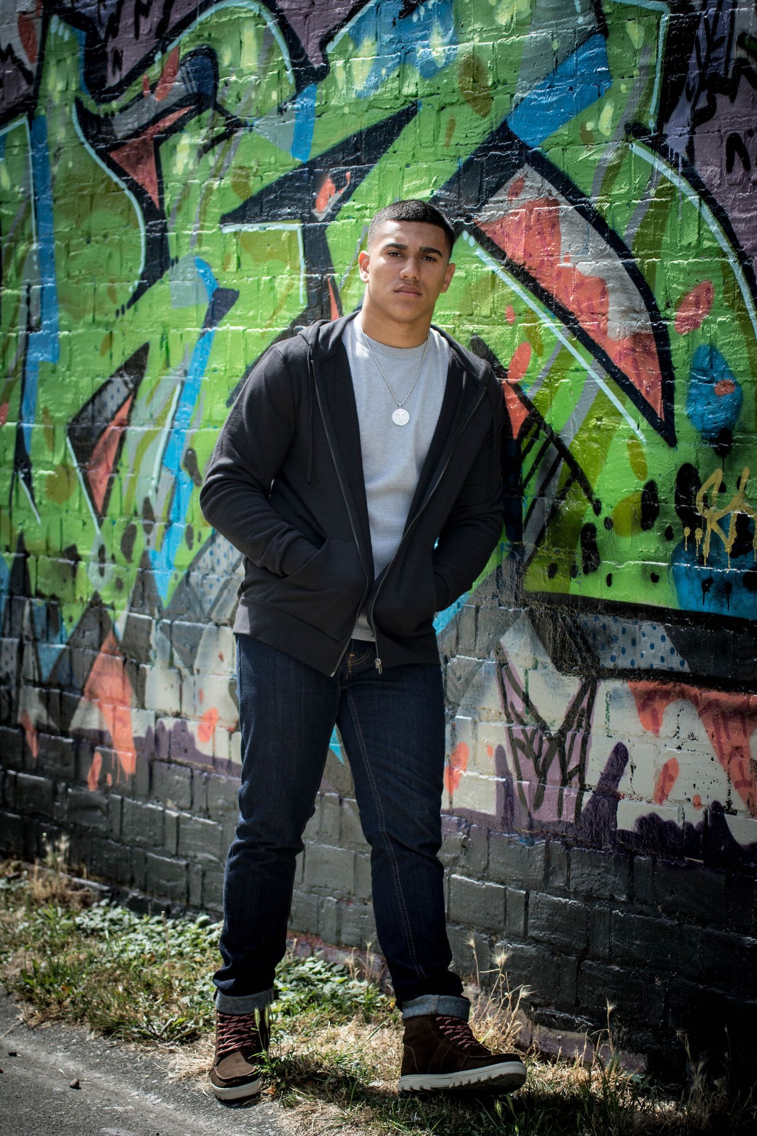 Urban portrait session with casual poses against graffiti wall background.