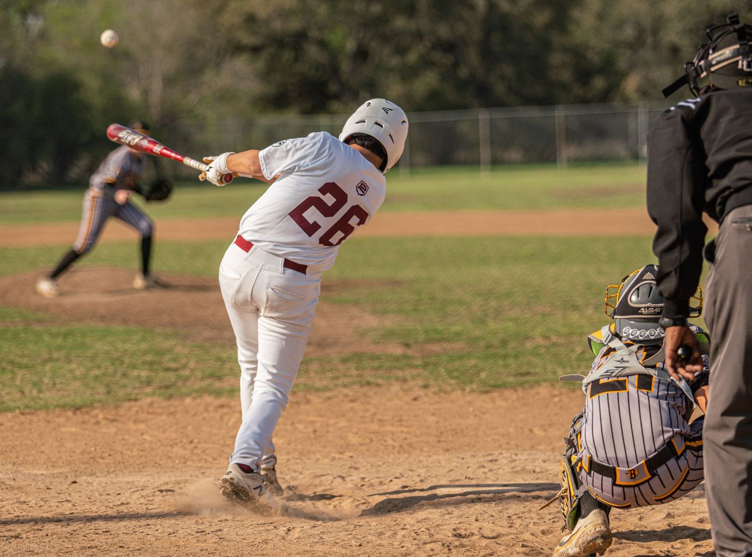Baseball batting sequence showing player swinging at pitch with catcher in position.