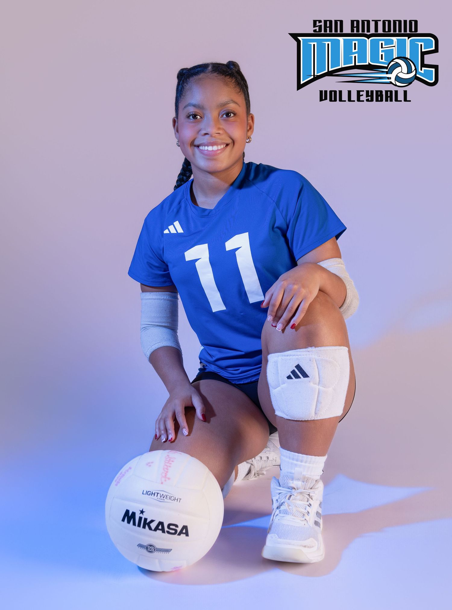 Player in blue jersey kneels with Mikasa volleyball against gradient purple background.