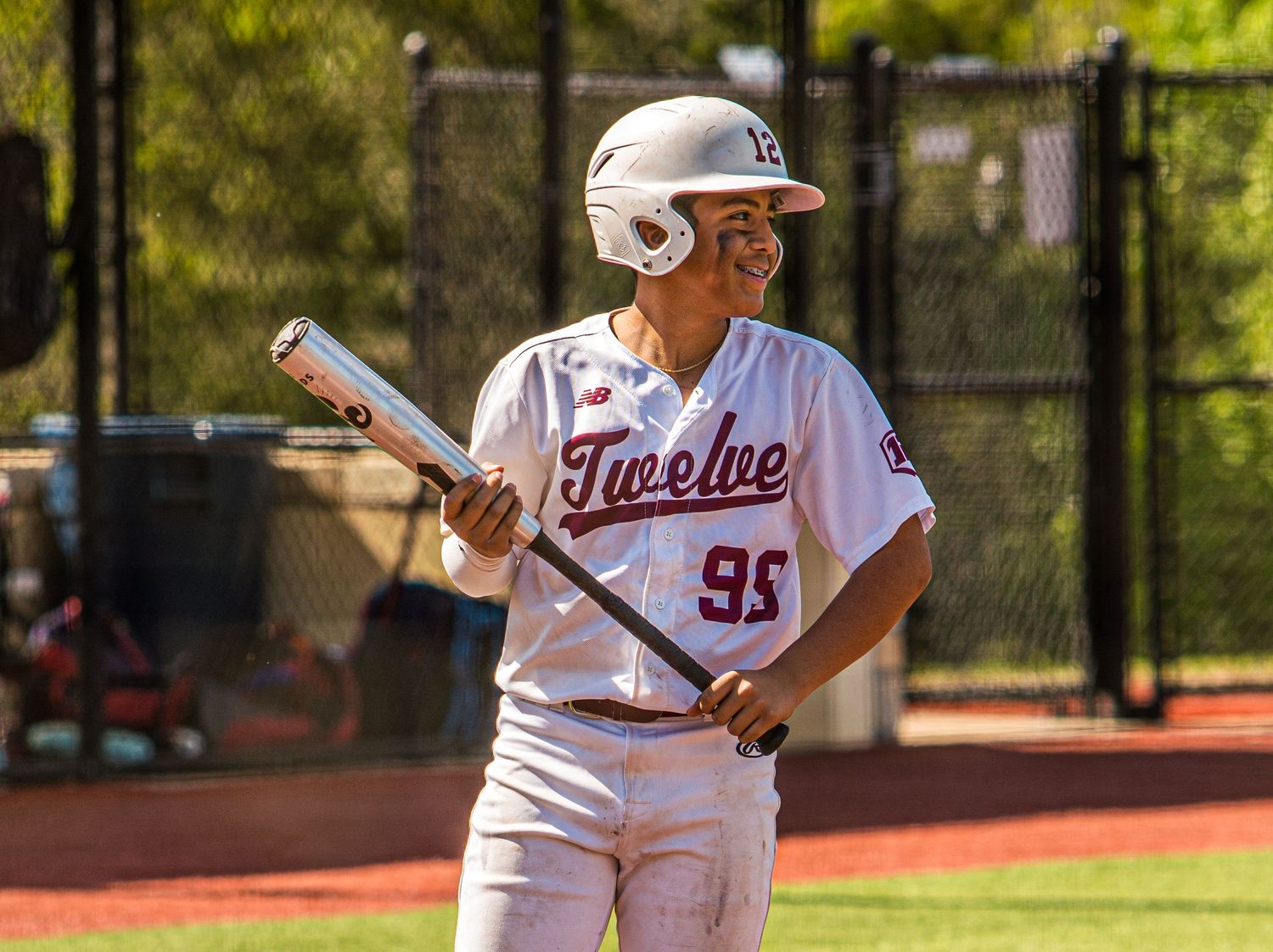 Baseball players in white uniforms on field during competitive game action.