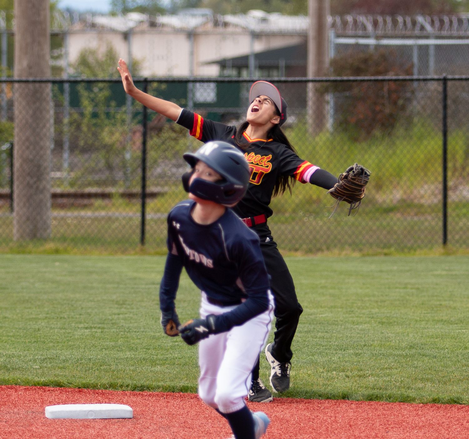 Baseball players collide during a play near second base on artificial turf field.