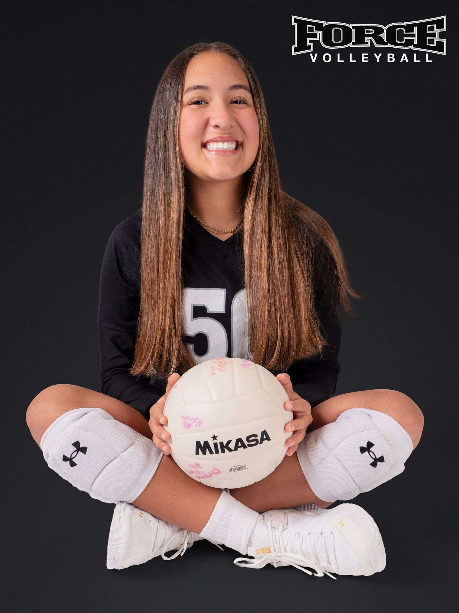 Studio shots of volleyball player in black Force uniform holding Mikasa ball in various poses.