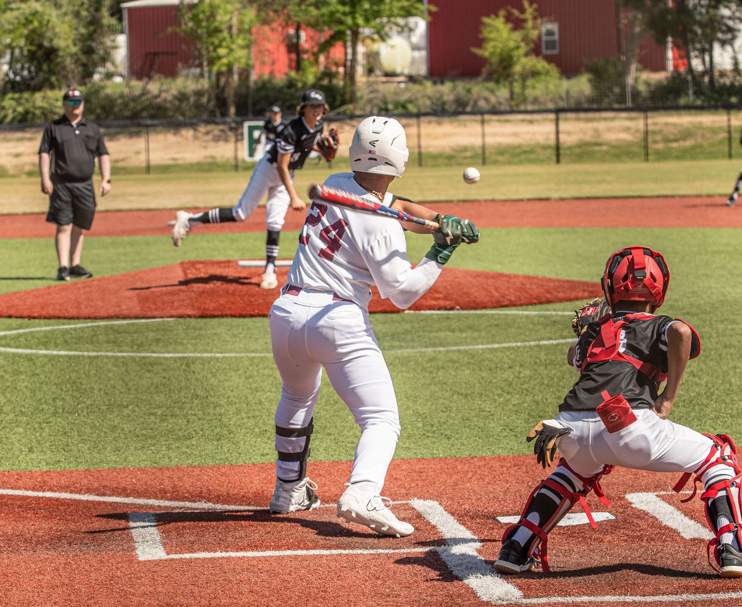 Baseball player sliding into home plate during game while catcher prepares to make the tag.