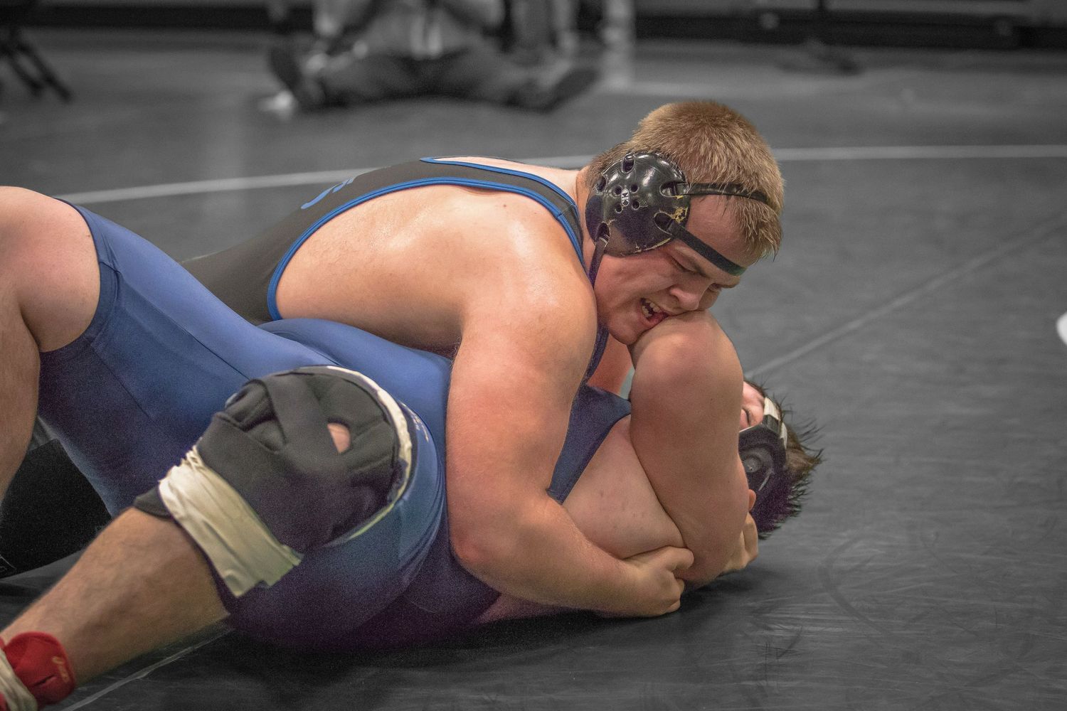 Wrestlers locked in a competitive ground position during a match.