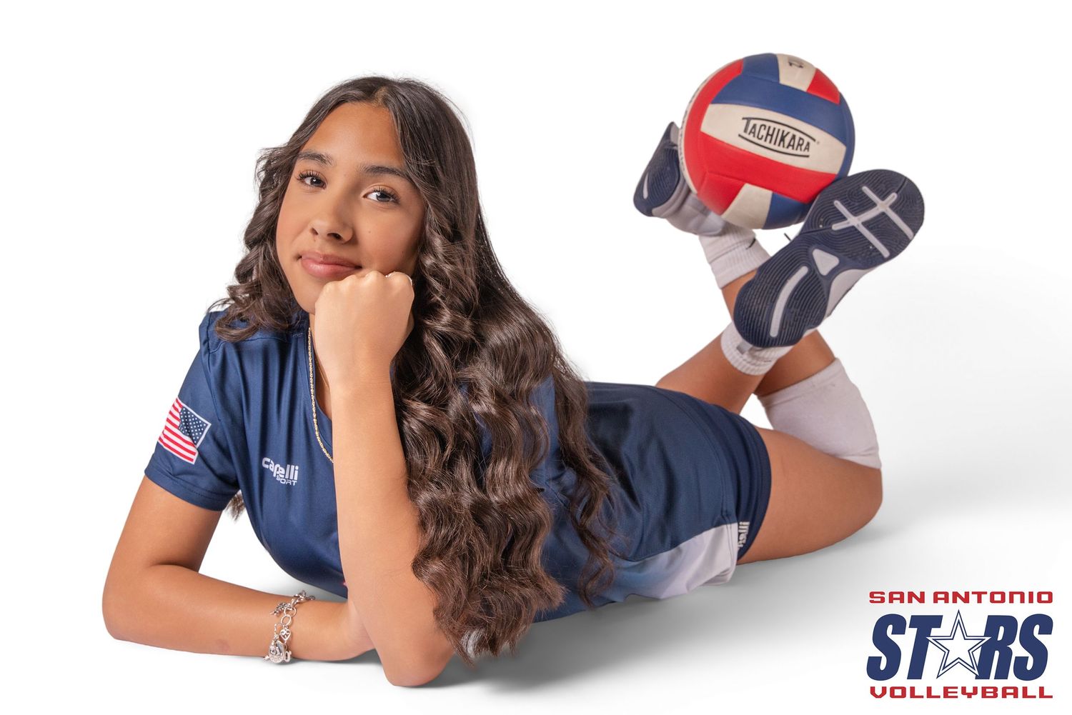 Athlete in navy blue uniform with Stars logo lying on stomach in various poses for sports team photo shoot.