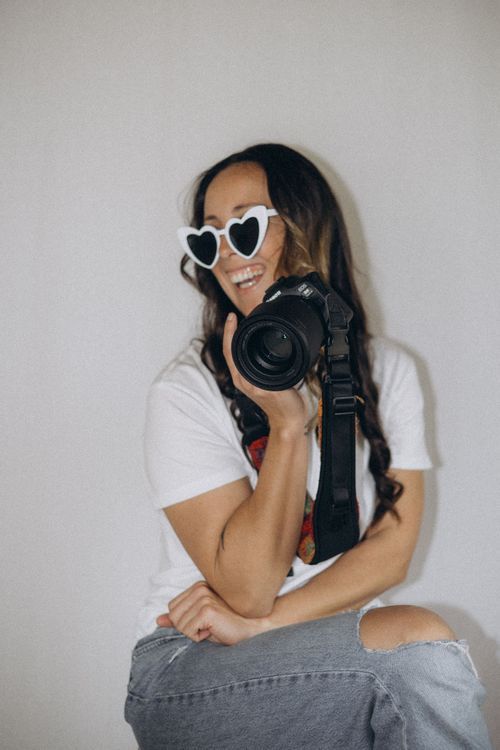Stephani, lead photographer at Olive June Moments, laughing behind the camera during a portrait session in Tauranga, New Zealand.
