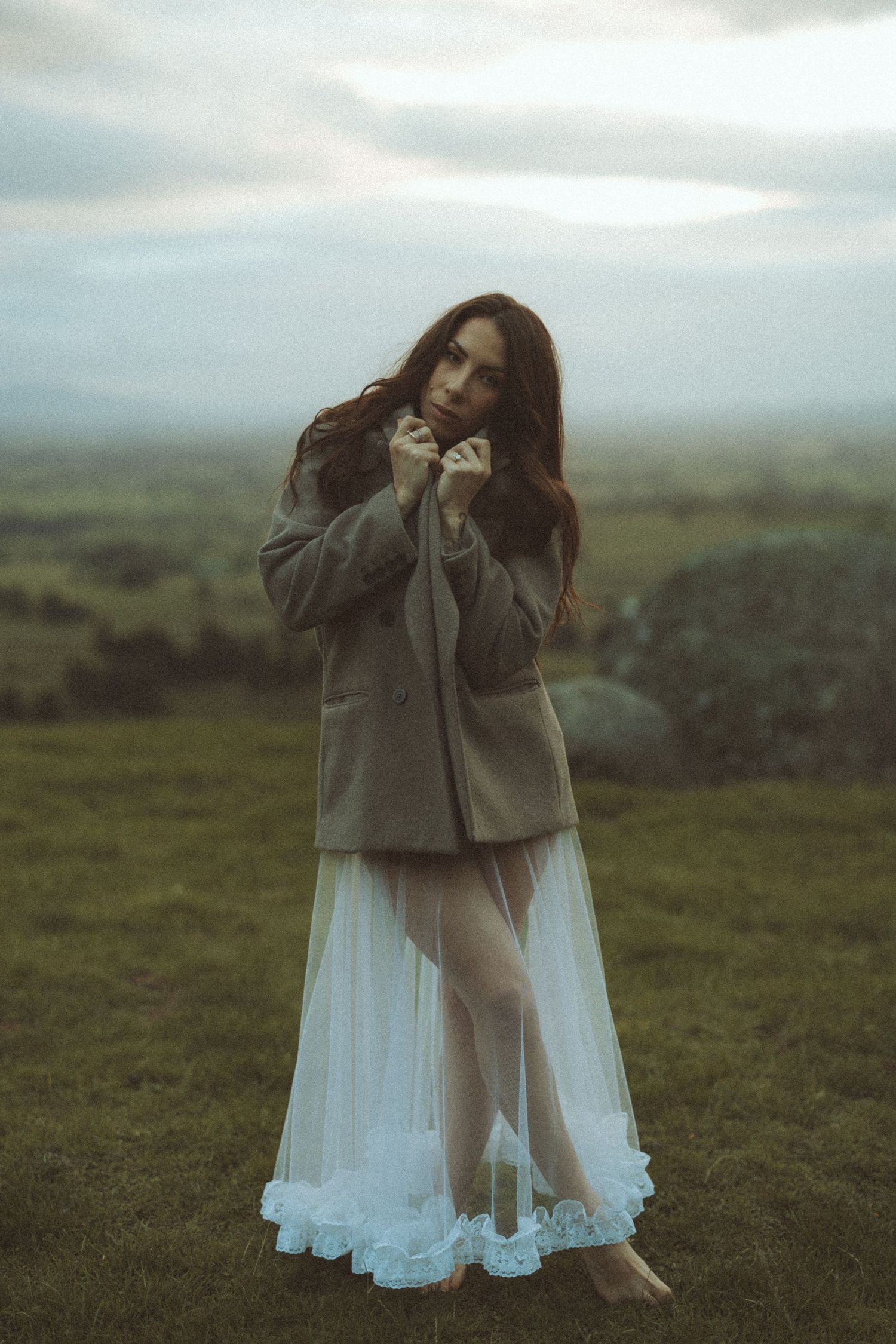 Soft cinematic portrait featuring a veil blowing in the wind during a moody countryside lifestyle photography session near Tauranga.