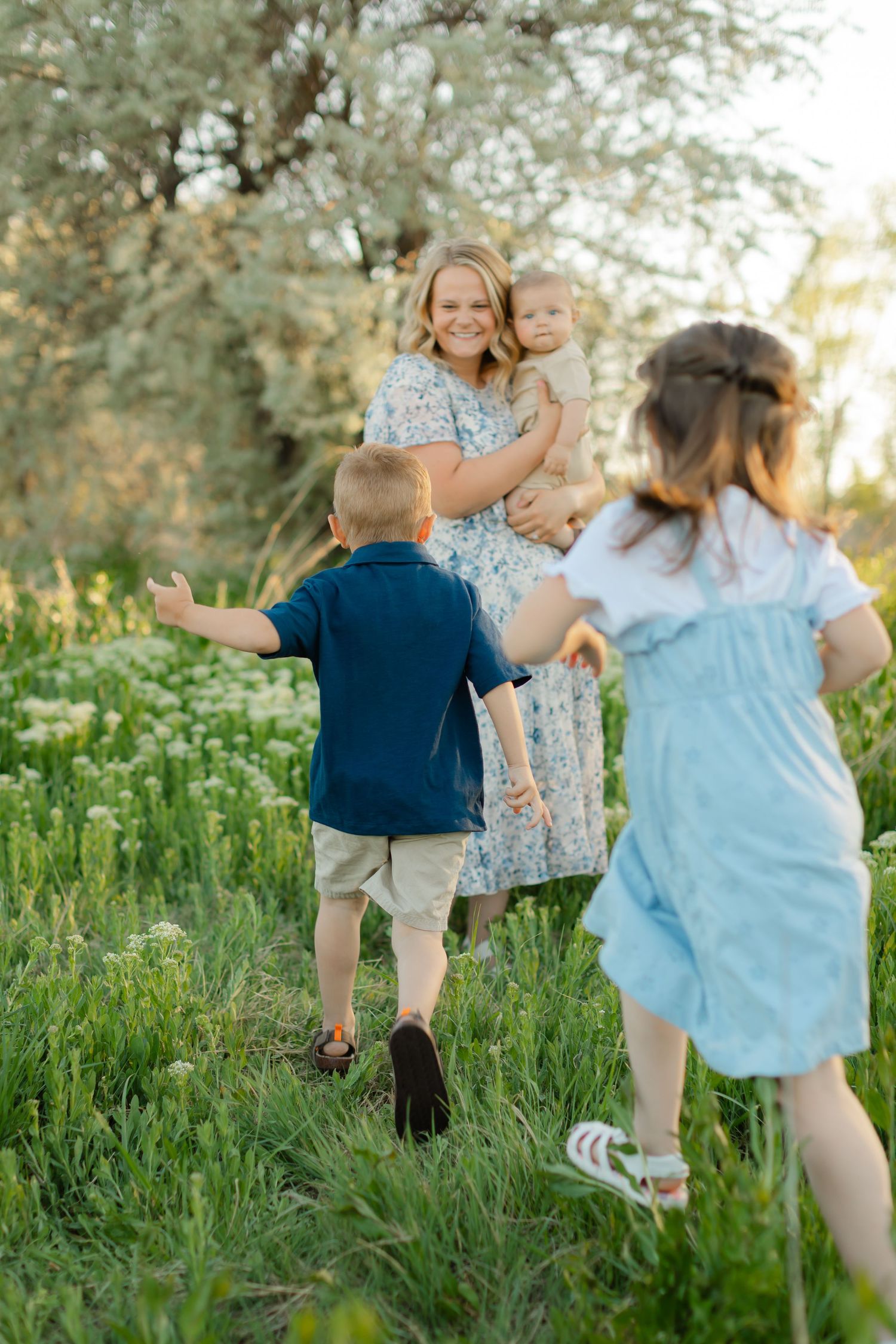 Family enjoying a spring day together outdoors in a wildflower meadow at sunset.