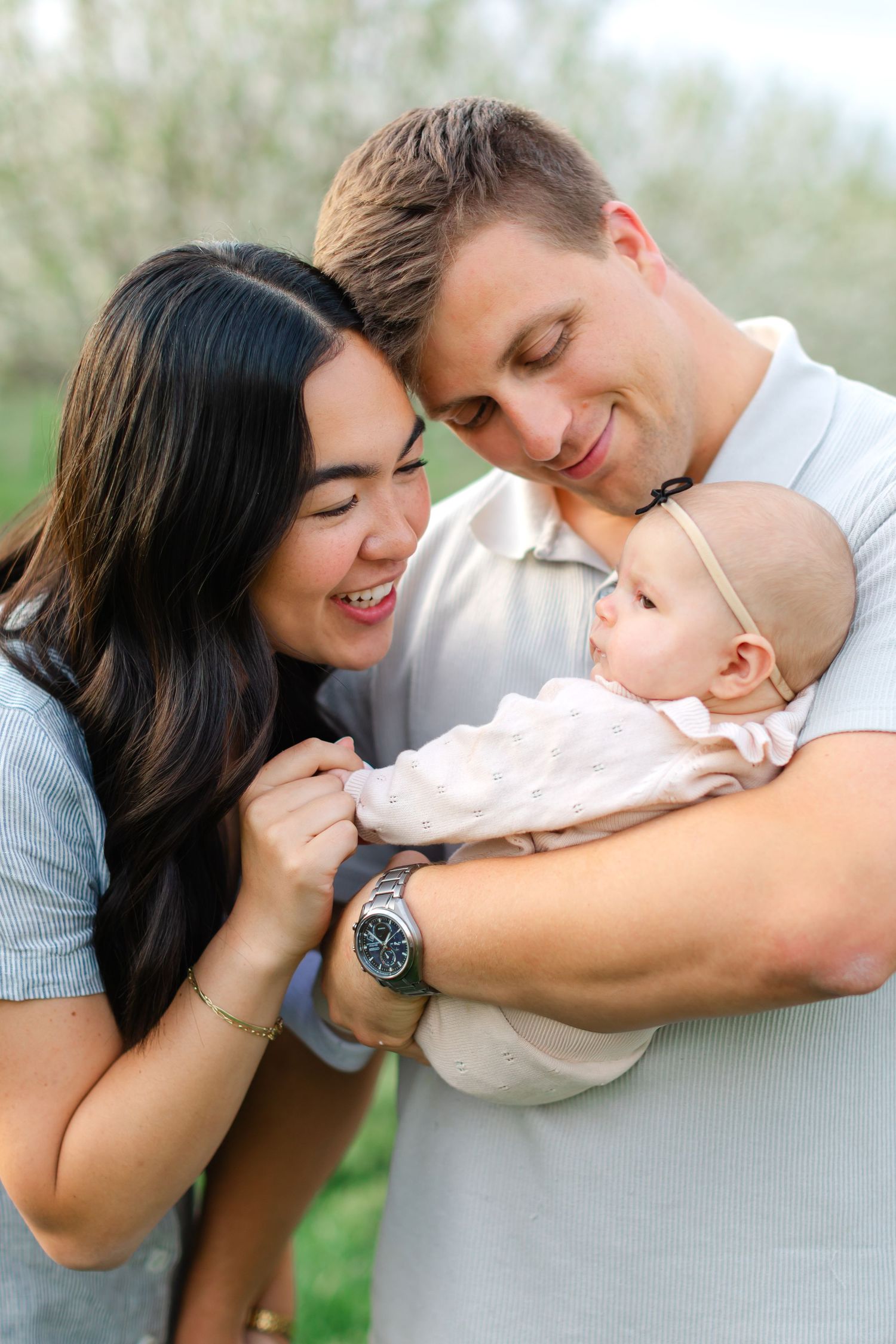 A loving family shares tender moments together in a series of outdoor portrait photographs.
