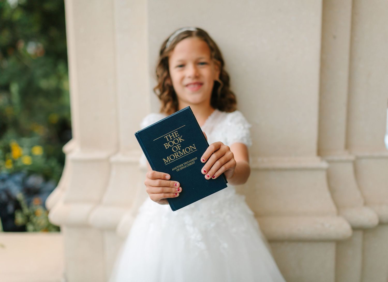A collection of passport photos showing hands holding passports against a white column backdrop outdoors.