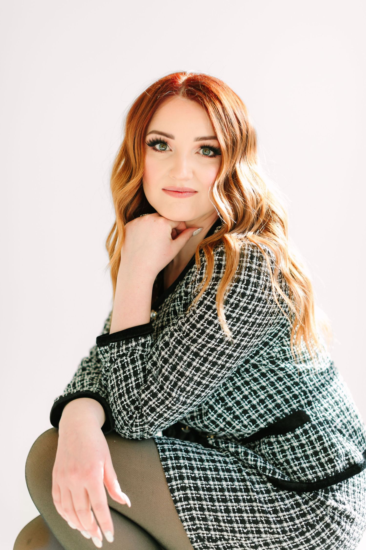 Woman with red hair wearing a black and white patterned scarf poses in three different positions.
