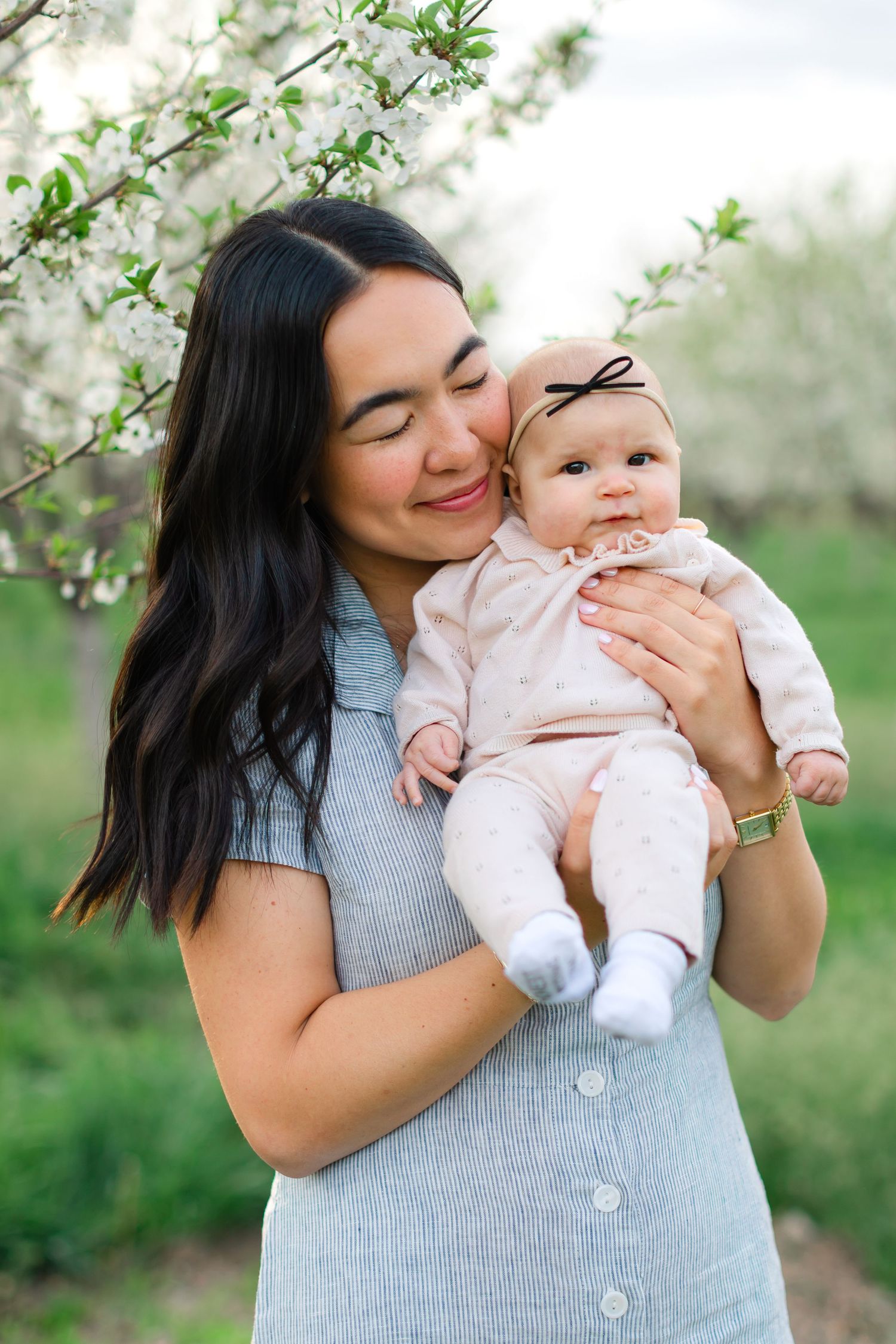 A tender moment captured in a spring garden setting with blooming white flowers in the background.